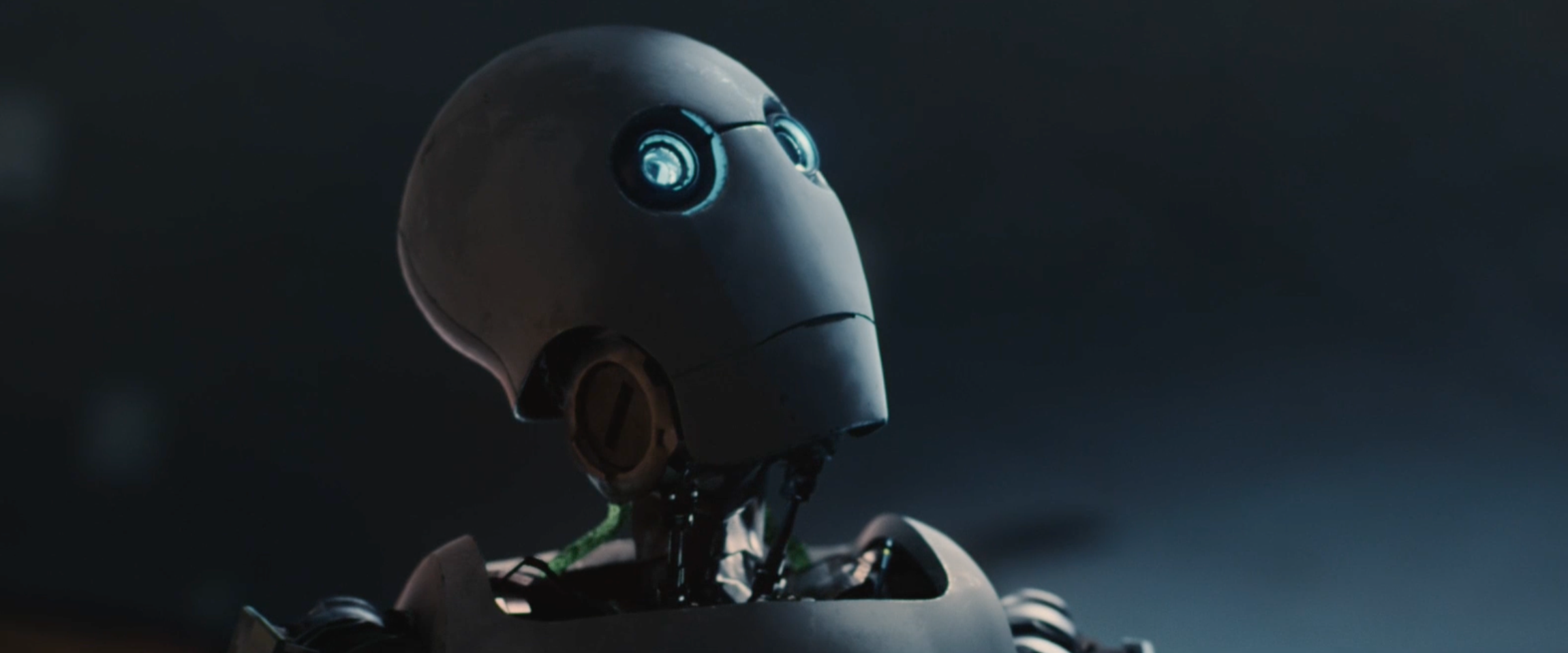A humanoid robot with a spherical head and glowing blue eyes in a dark background.