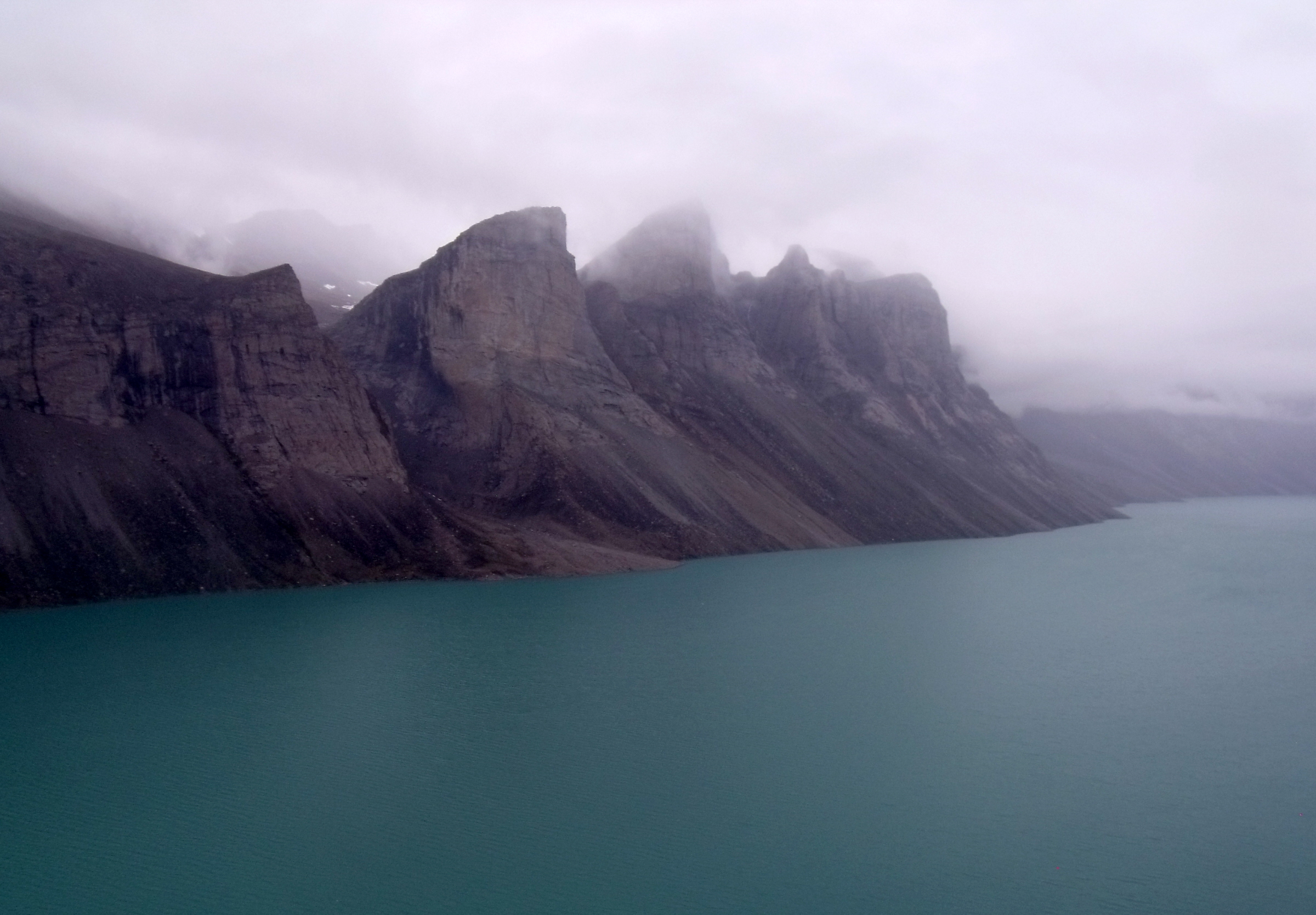  Land-locked freshwater fiord in northern Baffin Island, Nunavut with mile high teeth in the fog. Taken across Ayr Lake from a helicopter returning through the 'back door' to the hamlet of Clyde River. Photo by  Mike Beauregard &nbsp; 