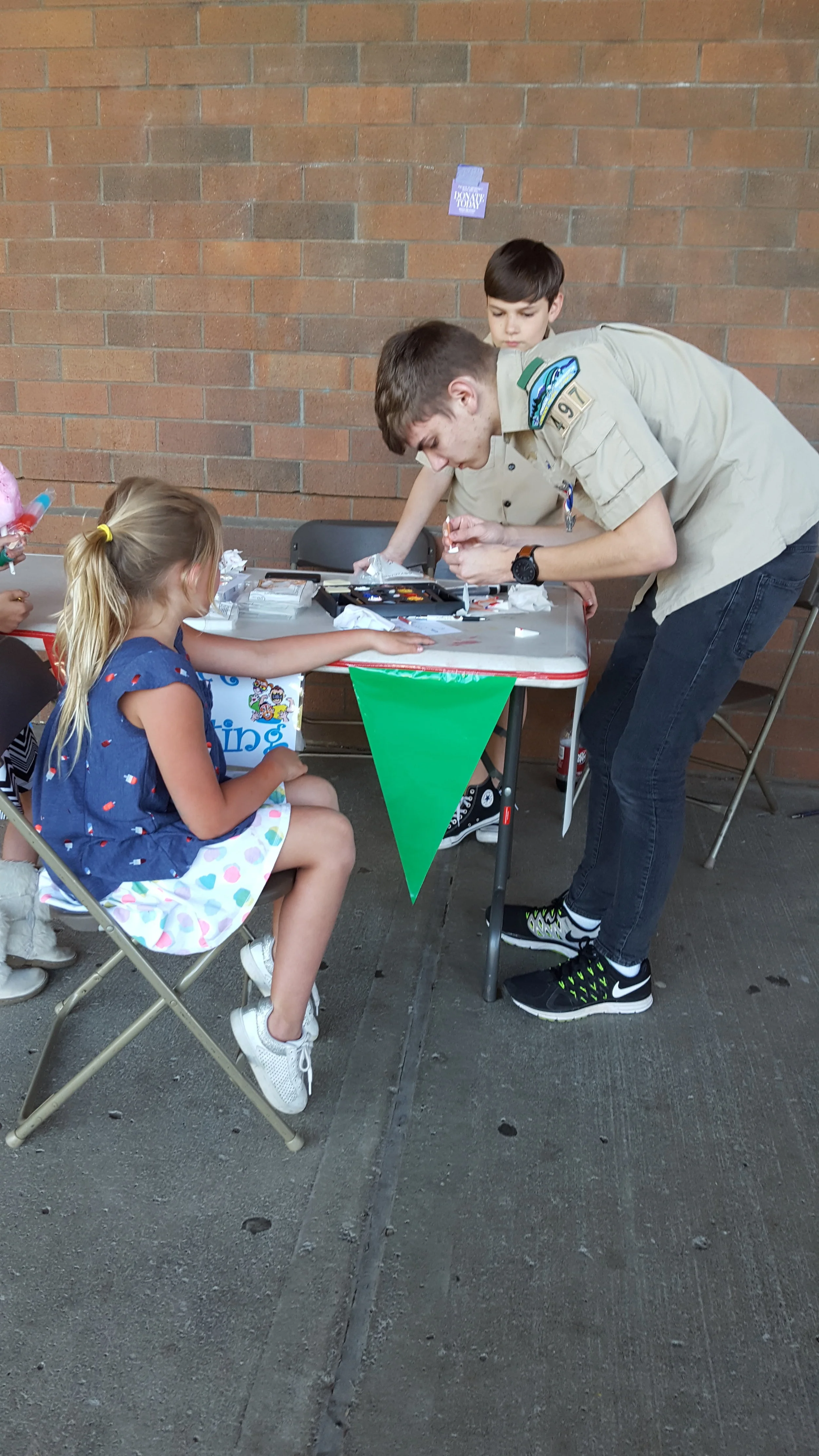 Volunteers from Troop 497 giving out tattoos at the carnival