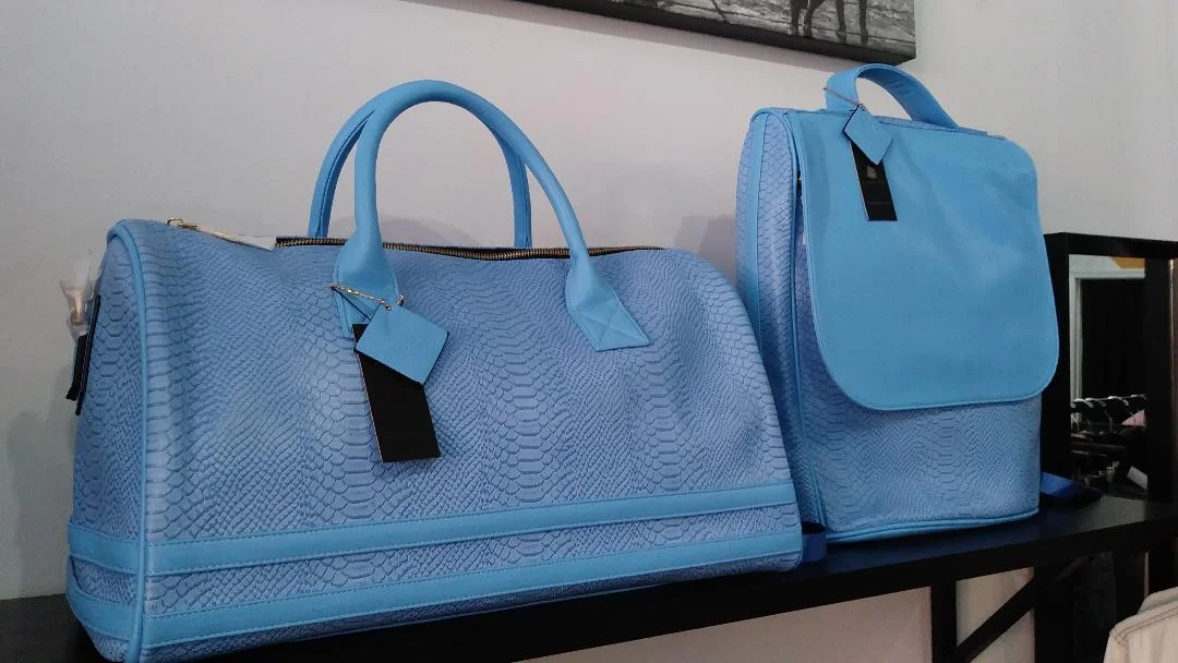 We are 1 of 10 stores nationwide to carry Tote&amp;Carry bags. These are designed by Buffalo born designer, Stitch Dr. (now of Atlanta). These are hand-made of ec0-friendly alligator leather, water-proof, stain &amp; scratch resistant. Sold in-store only. They come in: Sky Blue, Black, Mustard, Orange and Red.  Duffel Bags: $189, Back Pack: $140 (the set together is: $300)