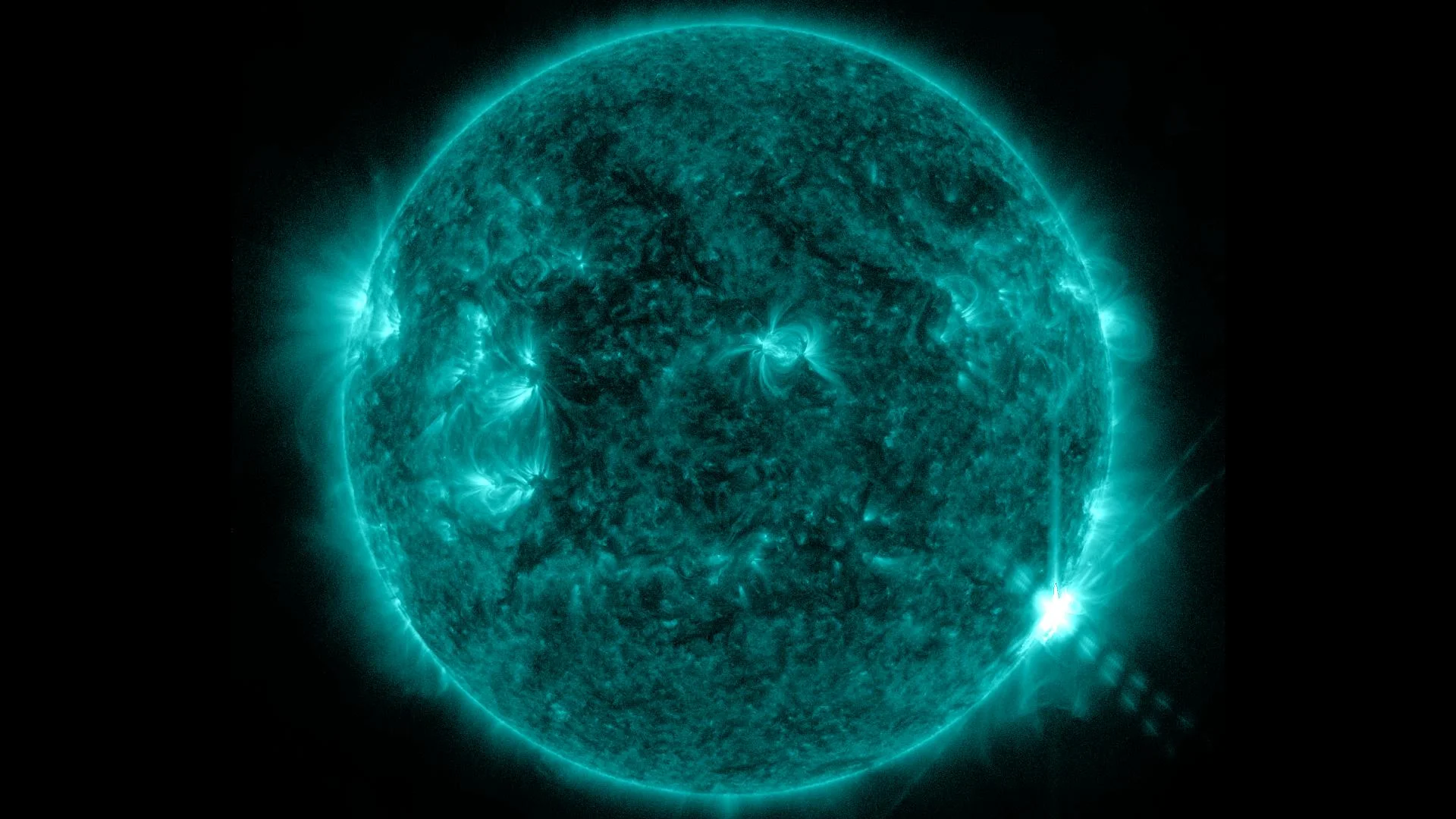 An M-class flare appears on the lower right of the sun on June 7, 2013. This image was captured by NASA’s Solar Dynamics Observatory in the 131 Angstrom wavelength, a wavelength of UV light that is particularly good for seeing flares and that is typically colorized in teal. Caption: NASA/SDO