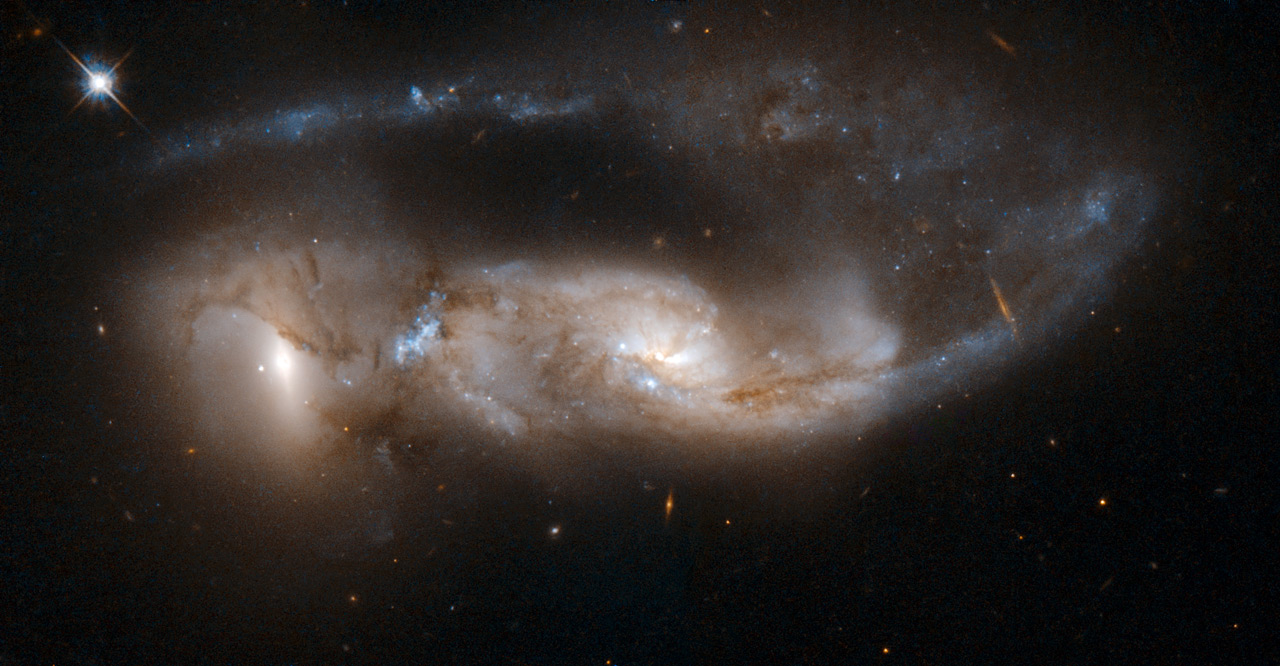 NGC 6621/2 (VV 247, Arp 81) is a strongly interacting pair of galaxies, seen about 100 million years after their closest approach. It consists of NGC 6621 (to the left) and NGC 6622 (to the right). NGC 6621 is the larger of the two, and is a very disturbed spiral galaxy. The encounter has pulled a long tail out of NGC 6621 that has now wrapped behind its body. Image credit: NASA, ESA, the Hubble Heritage (STScI/AURA)-ESA/Hubble Collaboration, and W. Keel (University of Alabama, Tuscaloosa)