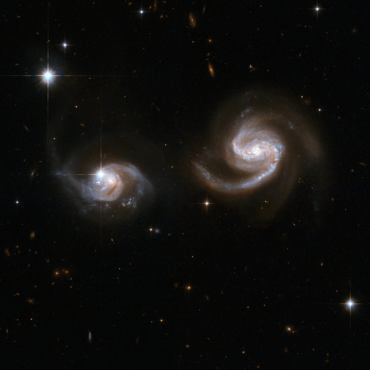 This Hubble image displays a beautiful pair of interacting spiral galaxies with swirling arms. The smaller of the two, dubbed LEDA 62867 and positioned to the left of the frame, seems to be safe for now, but will probably be swallowed by the larger spiral galaxy, NGC 6786 (to the right) eventually. Image Credit: NASA, ESA, the Hubble Heritage (STScI/AURA)-ESA/Hubble Collaboration, and A. Evans (University of Virginia, Charlottesville/NRAO/Stony Brook University)