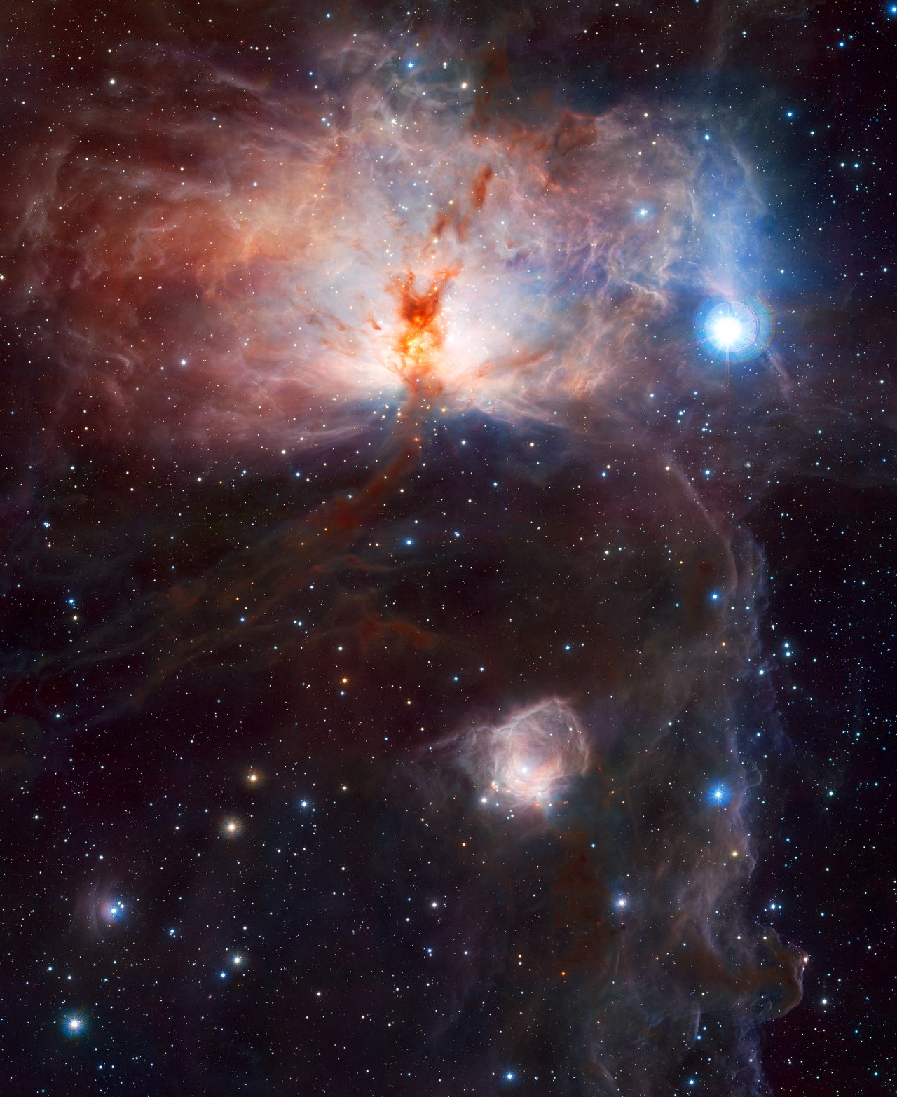 This image, the first to be released publicly from VISTA, the world’s largest survey telescope, shows the spectacular star-forming region known as the Flame Nebula, or NGC 2024, in the constellation of Orion (the Hunter) and its surroundings. In views of this evocative object in visible light the core of the nebula is completely hidden behind obscuring dust, but in this VISTA view, taken in infrared light, the cluster of very young stars at the object’s heart is revealed. The wide-field VISTA view also includes the glow of the reflection nebula NGC 2023, just below centre, and the ghostly outline of the Horsehead Nebula (Barnard 33) towards the lower right. The bright bluish star towards the right is one of the three bright stars forming the Belt of Orion. The image was created from VISTA images taken through J, H and Ks filters in the near-infrared part of the spectrum. The image shows about half the area of the full VISTA field and is about 40 x 50 arcminutes in extent. The total exposure time was 14 minutes. Image credit: ESO/J. Emerson/VISTA. Acknowledgment: Cambridge Astronomical Survey Unit