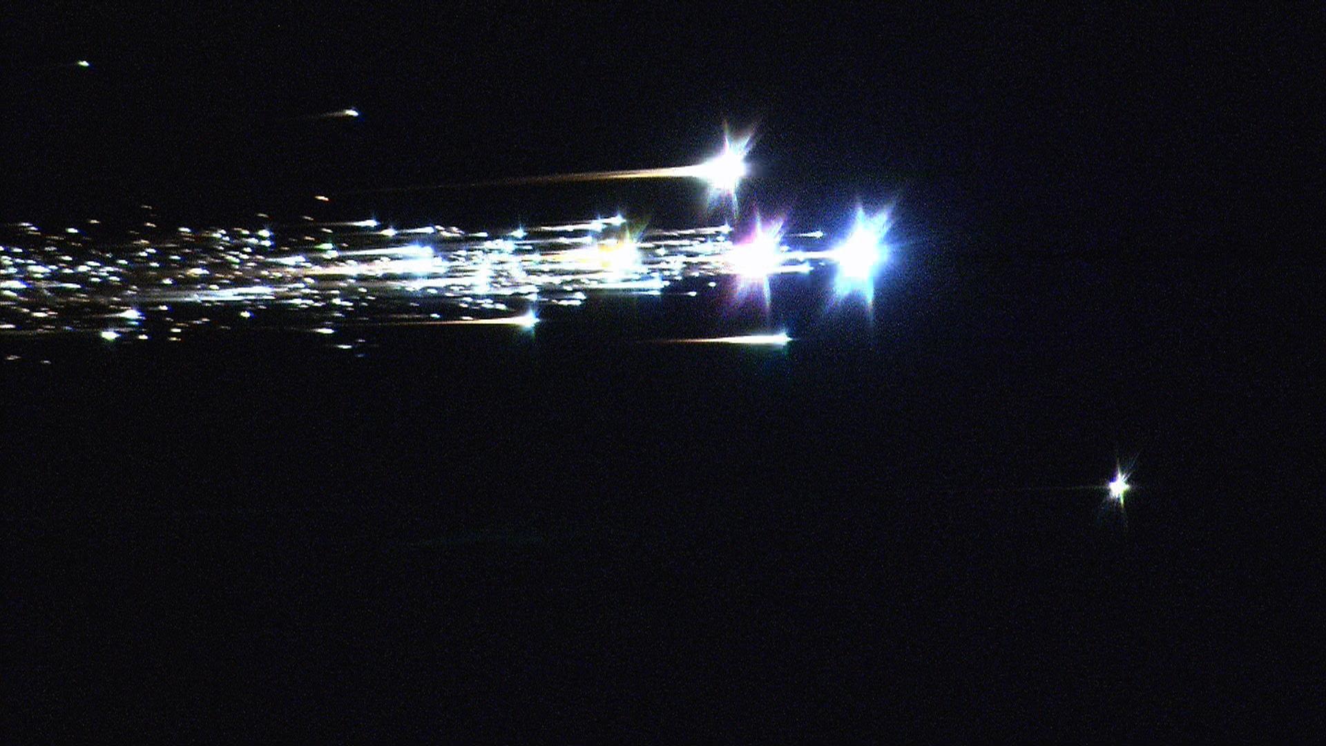 Scientists flying aboard NASA's DC-8 airborne laboratory captured this image of the Japan Aerospace Exploration Agency's Hayabusa spacecraft June 13, 2010 as it re-entered the Earth's atmosphere and began breaking up over the Woomera Test Range in southern Australia. The small object below and ahead of the main portion of the spacecraft was the sample return capsule, which was recovered intact after parachuting to a safe landing. JAXA scientists hope to recover samples of the asteroid Itokawa that Hayabusa visited in 2005 from the return container to help them understand the asteroid's composition. Image Credit: NASA