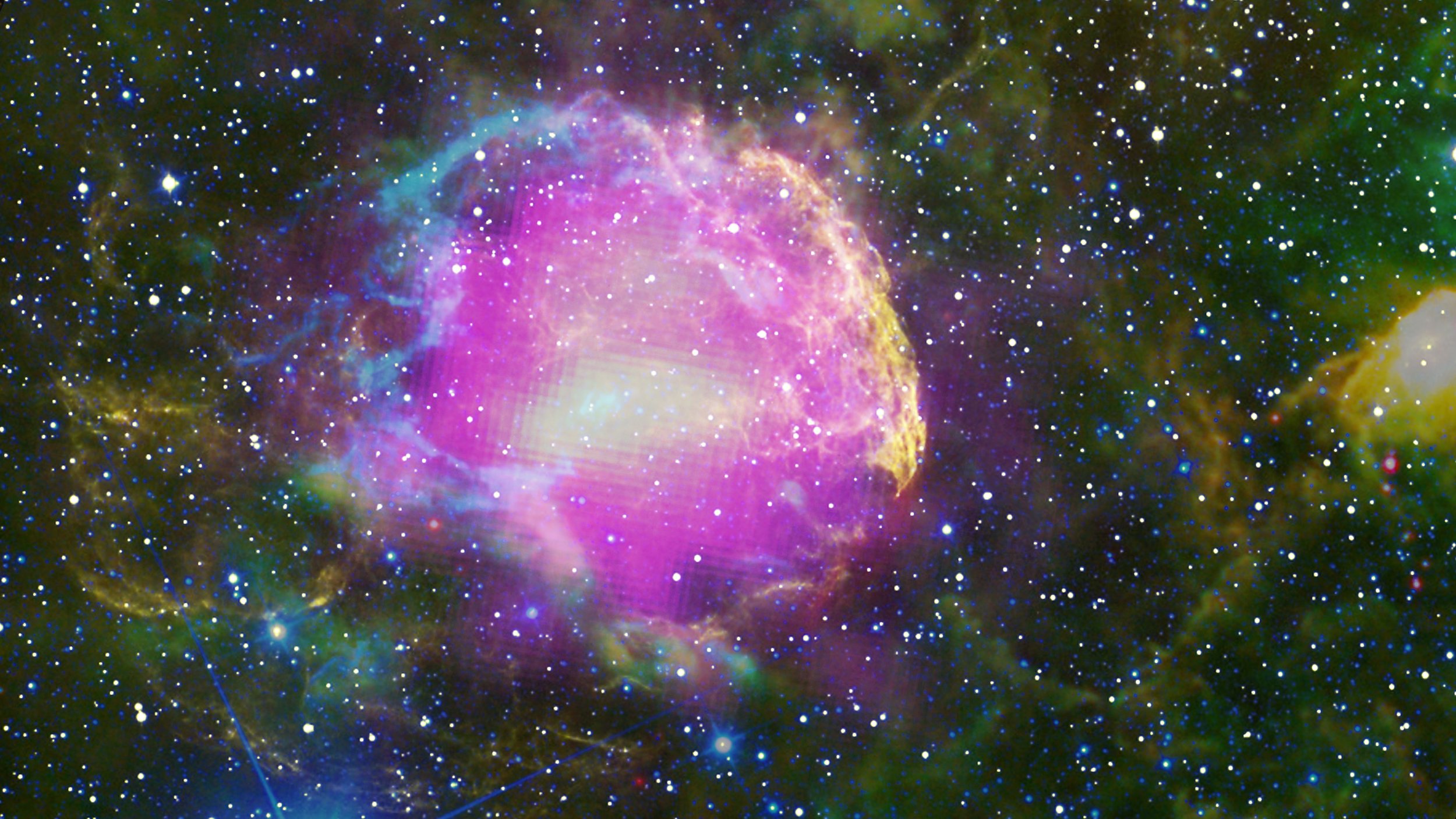 This multiwavelength composite shows the supernova remnant IC 443, also known as the Jellyfish Nebula. Fermi GeV gamma-ray emission is shown in magenta, optical wavelengths as yellow, and infrared data from NASA's Wide-field Infrared Survey Explorer (WISE) mission is shown as blue (3.4 microns), cyan (4.6 microns), green (12 microns) and red (22 microns). Image credit: NASA/DOE/Fermi LAT Collaboration, Tom Bash and John Fox/Adam Block/NOAO/AURA/NSF, JPL-Caltech/UCLA