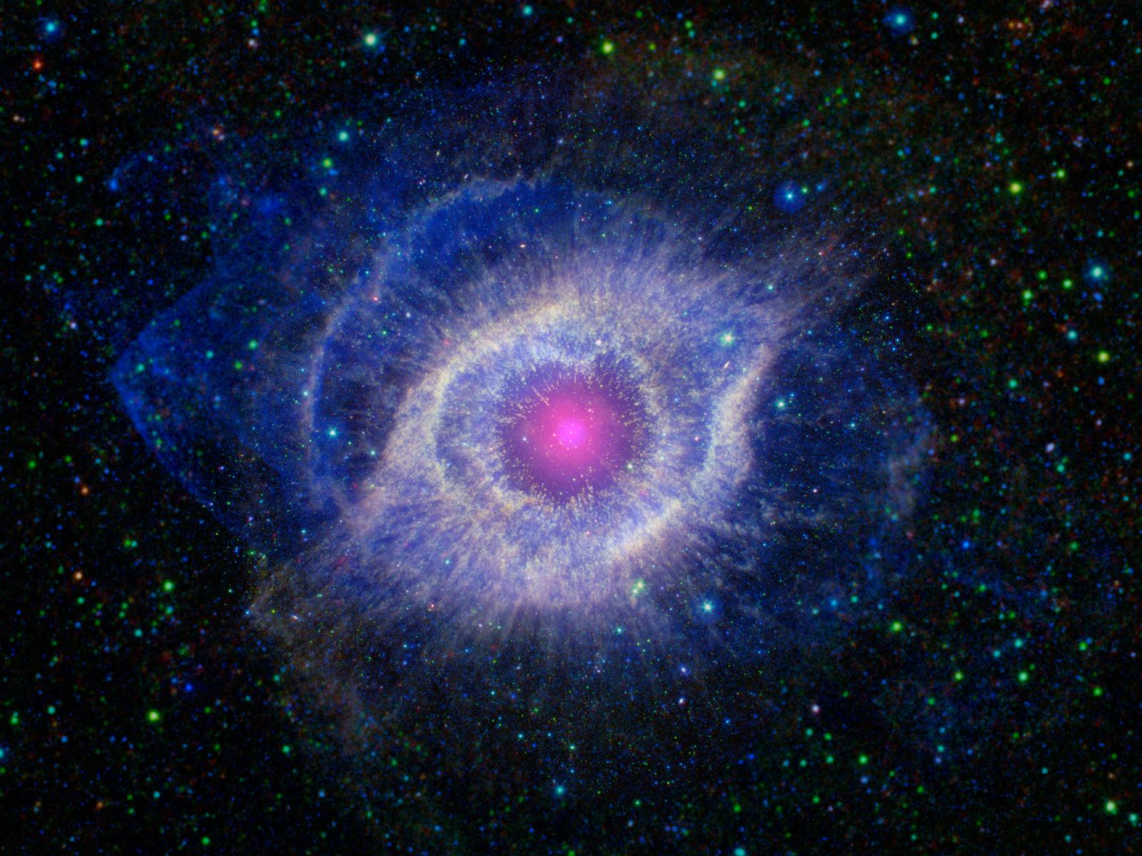 A dying star is throwing a cosmic tantrum in this combined image from NASA's Spitzer Space Telescope and the Galaxy Evolution Explorer (GALEX). In death, the star's dusty outer layers are unraveling into space, glowing from the intense ultraviolet radiation being pumped out by the hot stellar core. This object, called the Helix nebula, lies 650 light-years away, in the constellation of Aquarius. Image credit: NASA/JPL-Caltech