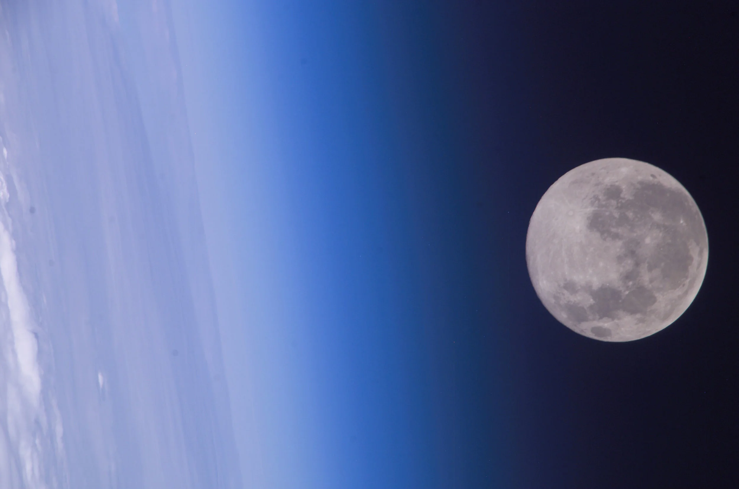 Framed by the Earth's horizon and airglow, the full moon floats in the blackness of space in this photo from the Expedition 10 crew on board the International Space Station. Image credit: NASA