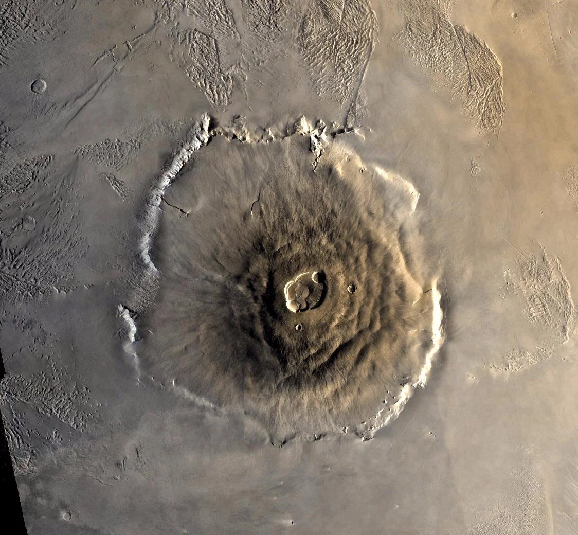 Color mosaic of Olympus Mons volcano on Mars from the Viking 1 Orbiter. The mosaic was created using images from orbit 735 taken 22 June 1978. Olympus Mons is about 600 km in diameter and the summit caldera is 24 km above the surrounding plains. Image credit: NASA/JPL
