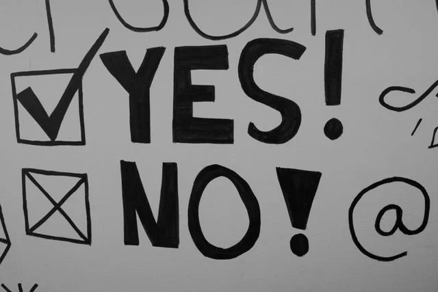Black and white image showing hand written yes and no with checkboxes next to them
