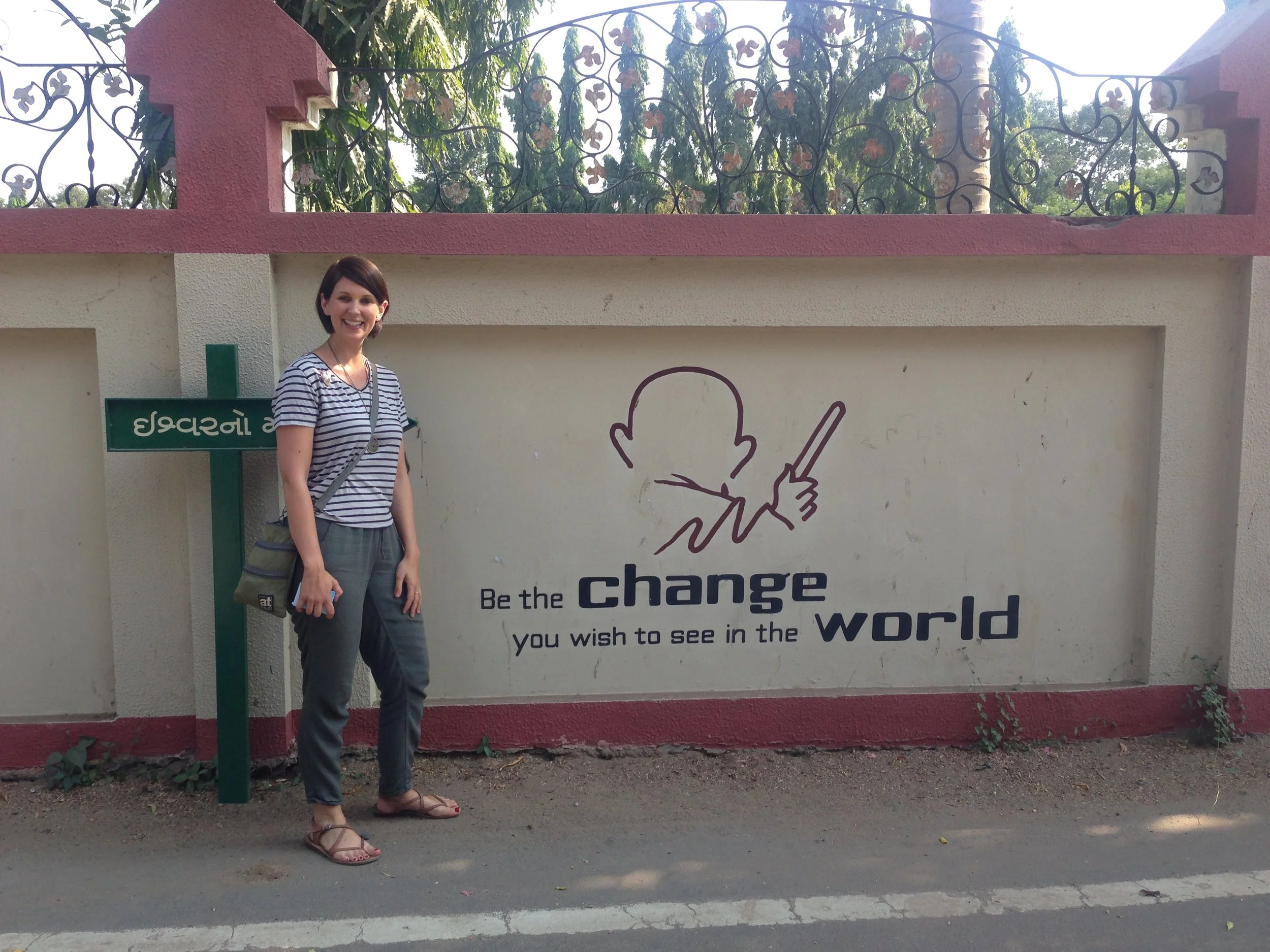 Photo fo Jo Green Career Coach in India by a sign saying 'Be the change you want to see in the world'