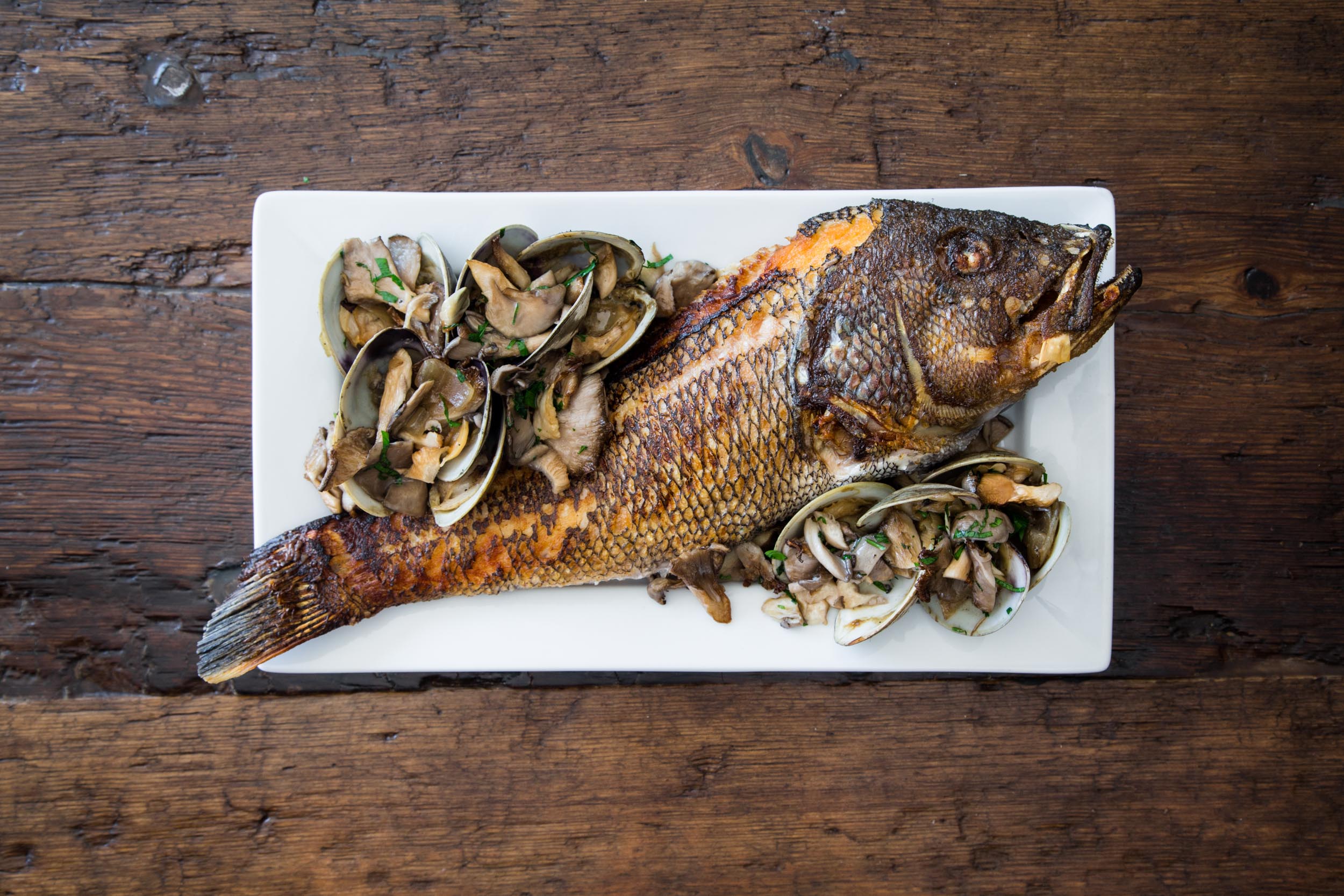 Crispy-Skin Striped Bass topped with a Leek, Wellfleet Clam, Vermouth, and Wild Mushroom Sauce