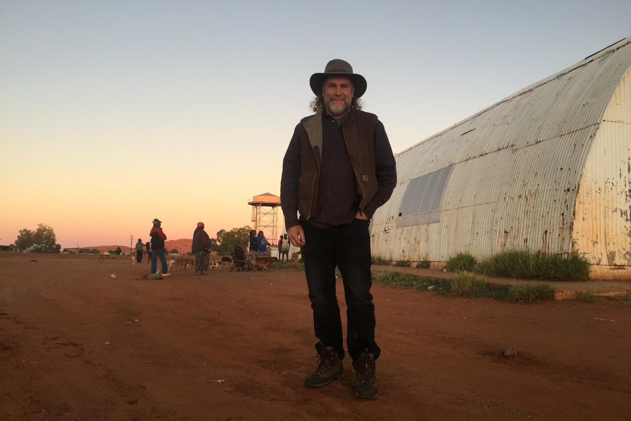 Pictured: Steve standing outside the old hall at Papunya community, Northern Territory. His first concert there was in the winter of 1996.