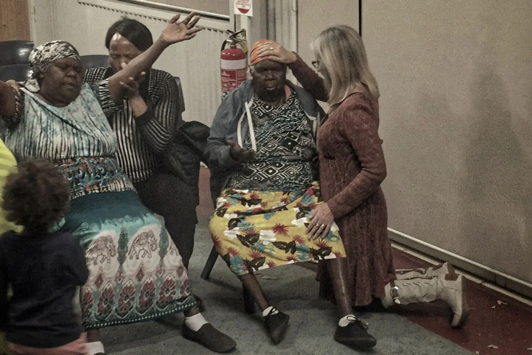 Pictured: Kerrie praying for Aunty May at the Kidman Street Church in Alice Springs.