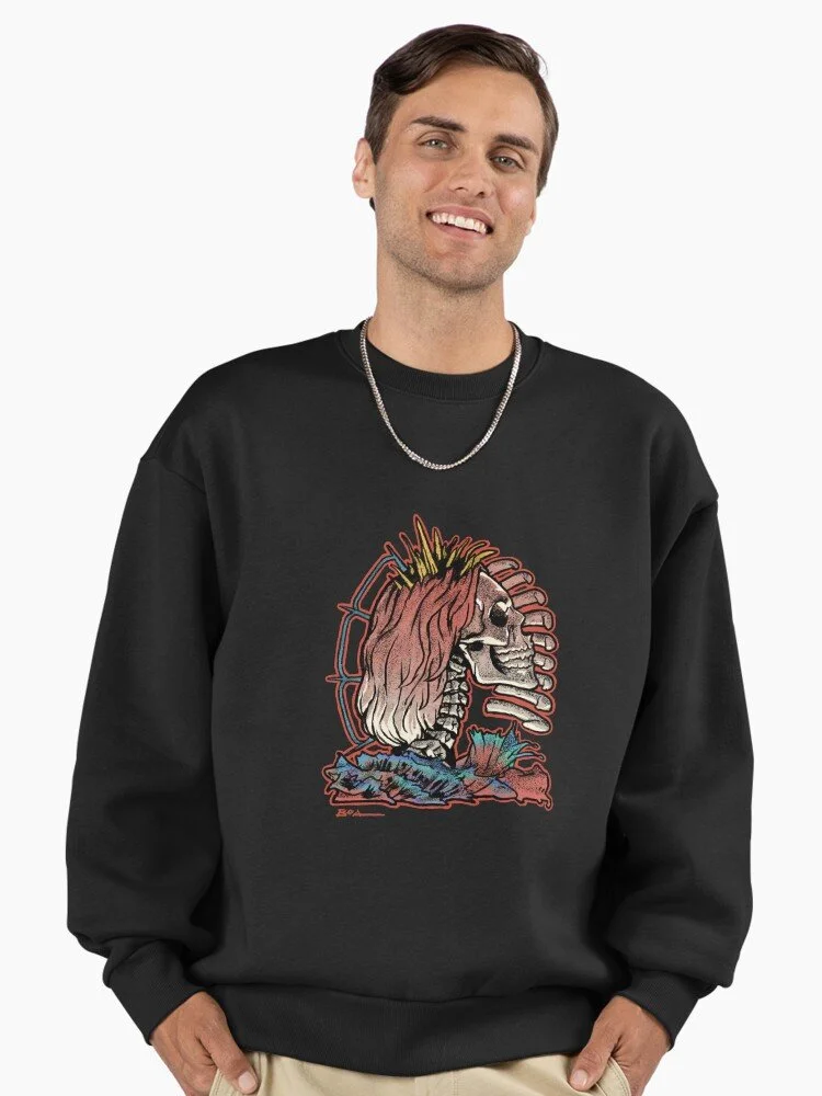 Young man wearing a black sweatshirt with a colorful illustration of a skeleton and a woman with pink hair, along with blue and red details.
