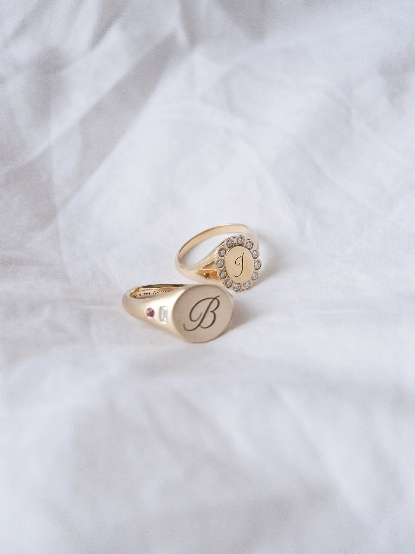 Who says wedding rings have to be a classic band?

These two bespoke signets were made for a couple who wanted something meaningful and a little bit fun. 

One features a full bloom of ethical diamonds surrounding a dainty hand-engraved initial. The 
