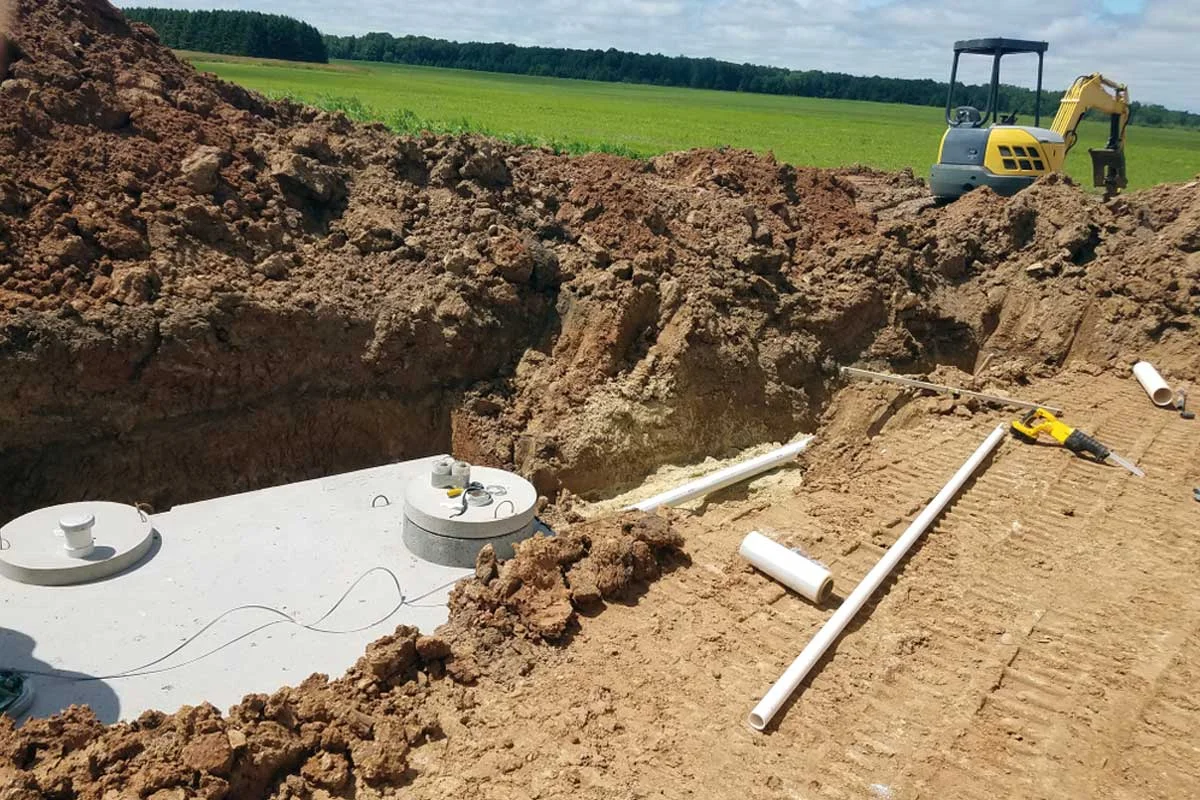 homeguide-excavator-digging-and-placing-a-concrete-septic-tank-system-install.jpg