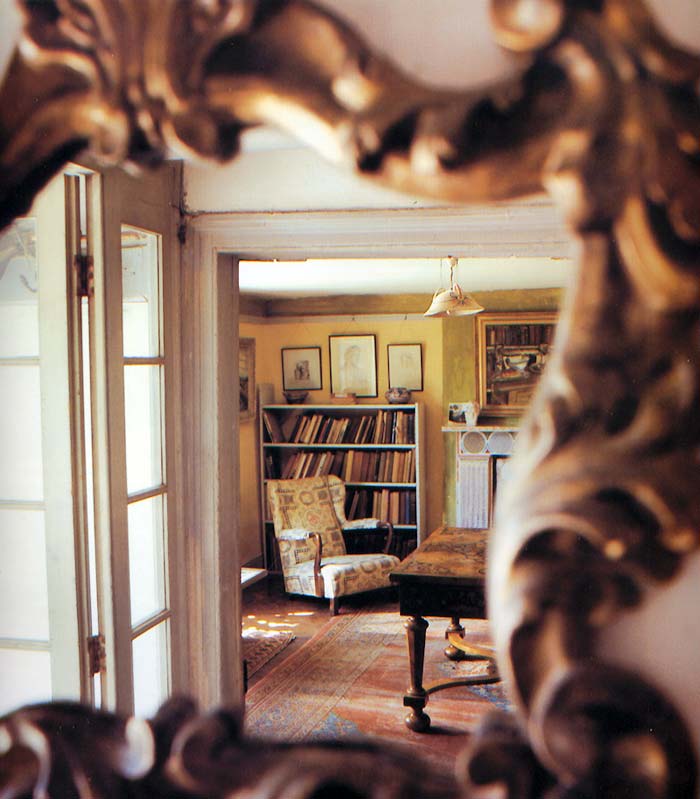 The nineteenth-century Italian gilt mirror in the hall reflects a view of Clive Bell's study through the open door.
