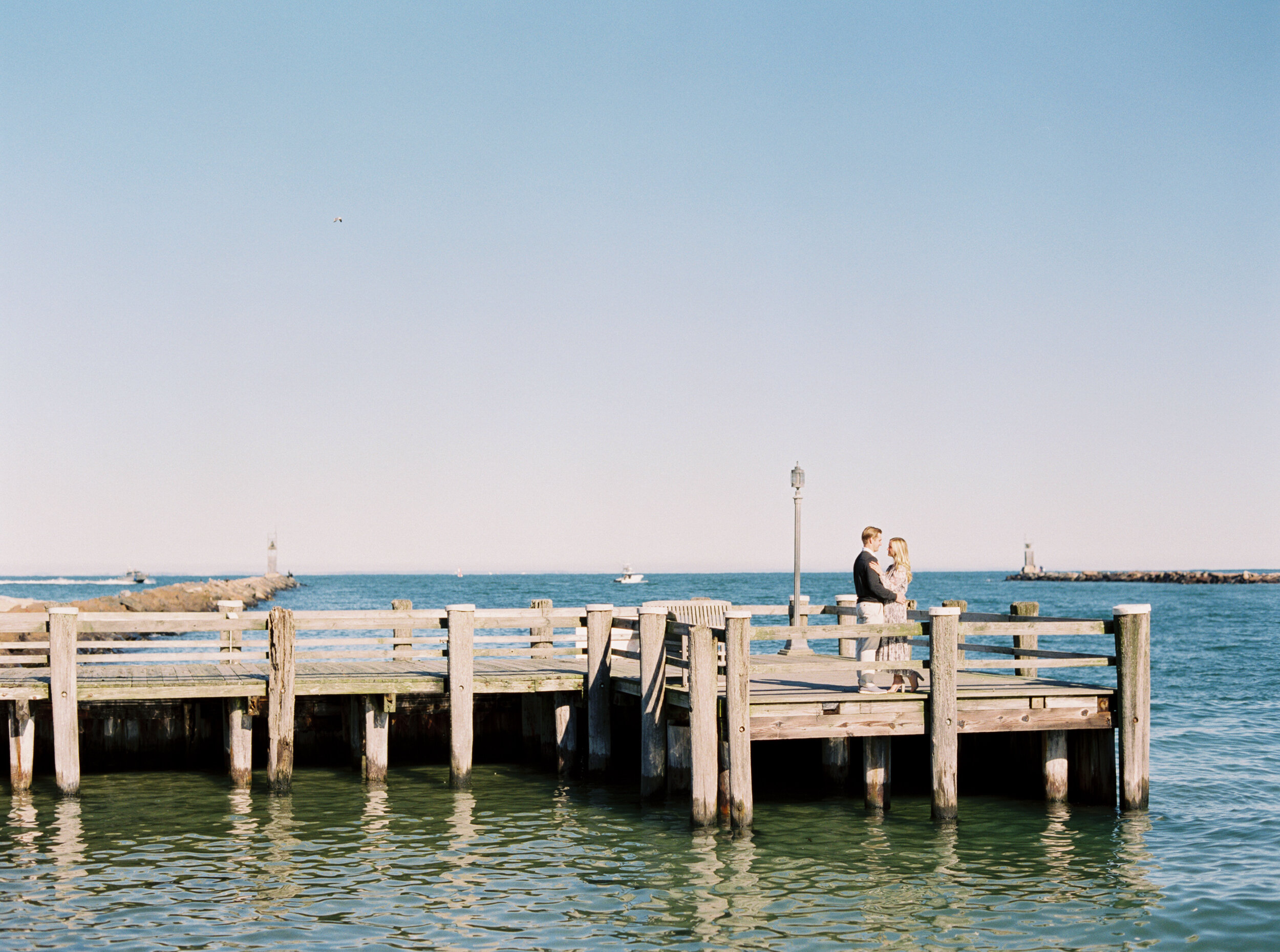 Couple on pier at engagement session in the hamptons