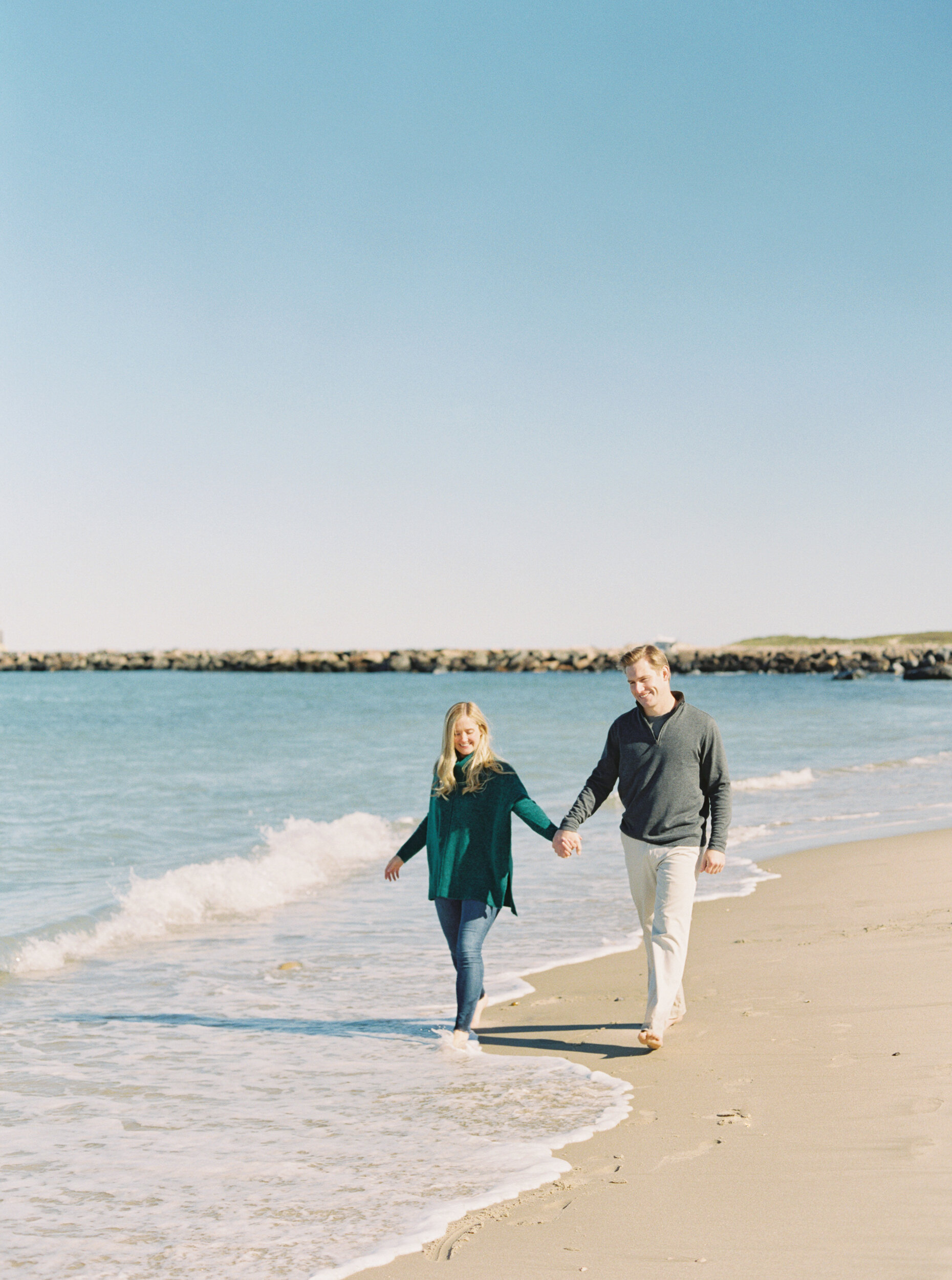 Walking in the ocean at engagement session in Montauk