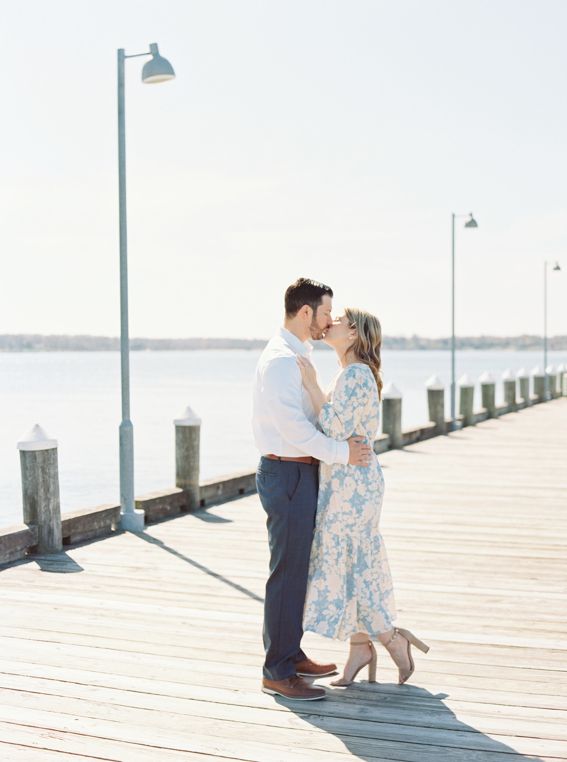 Couple kisses on pier at engagement session in Greenport, NY