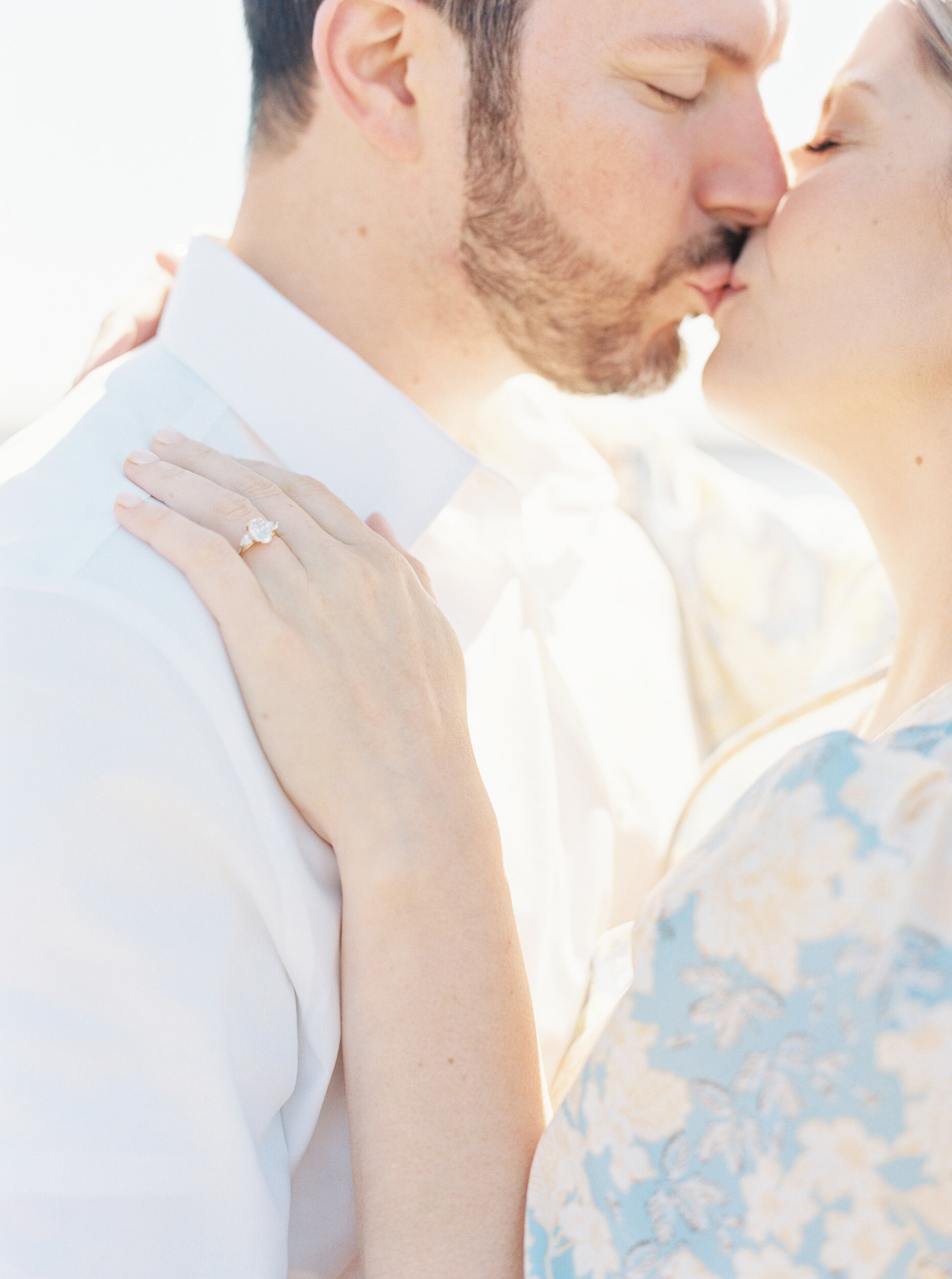 Couple kisses on pier at engagement session in Greenport, NY