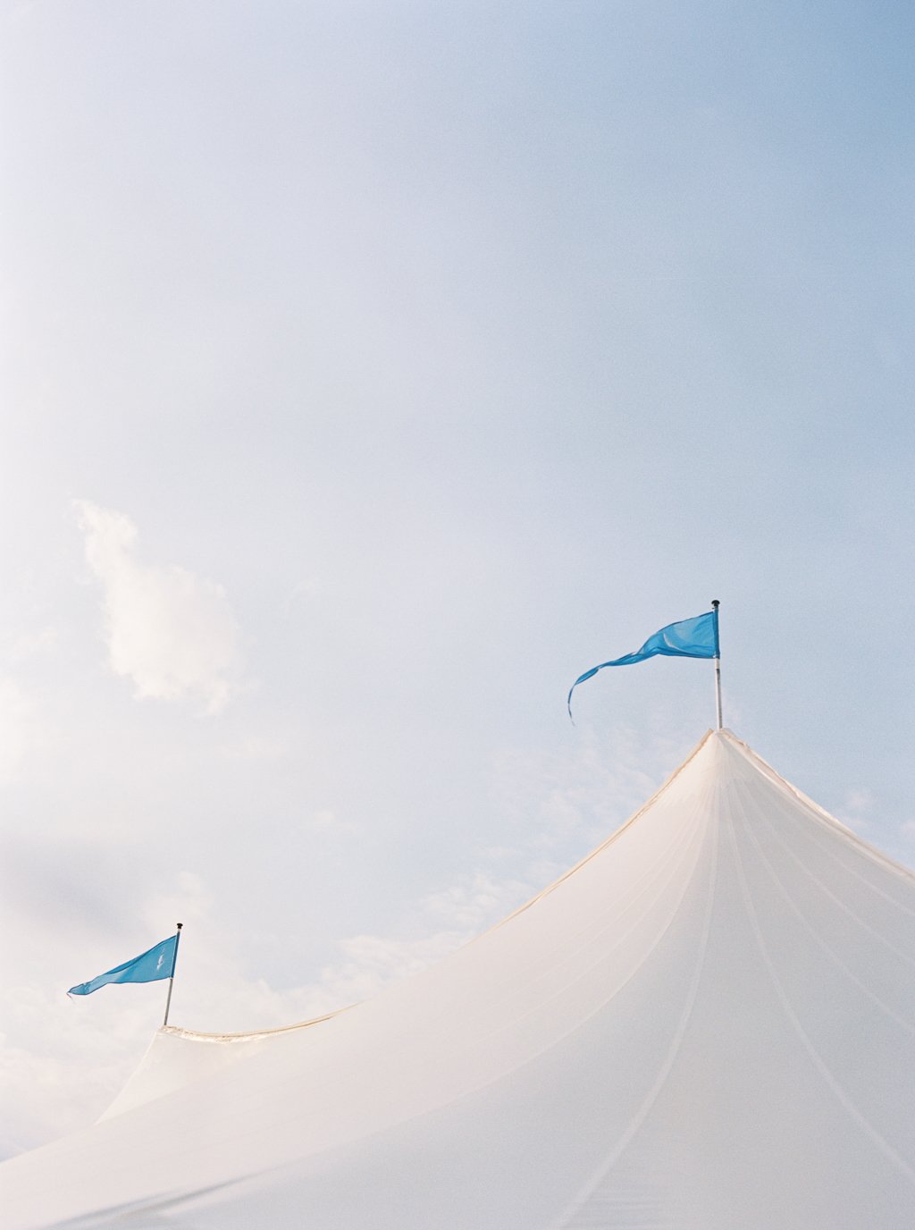 White SailCloth Tent Close Up of Blue Flags