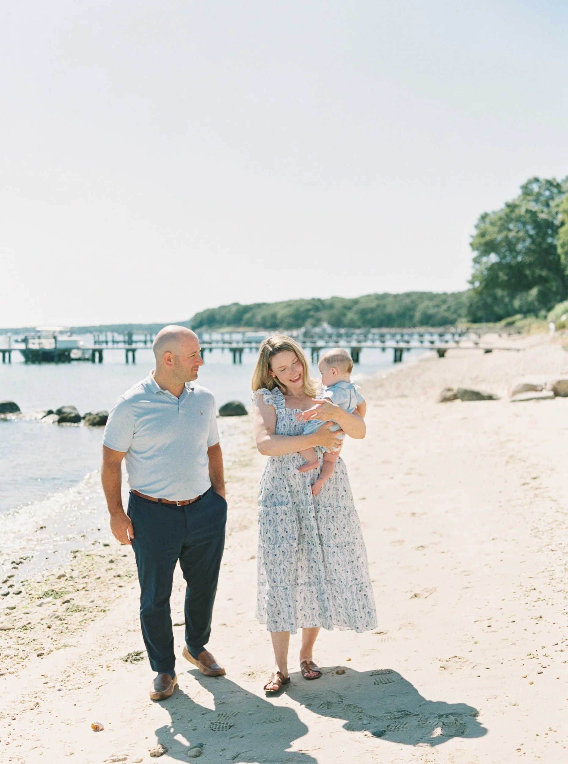 Parents walking on the beach with their son for their beach family photos in Sag Harbor, NY