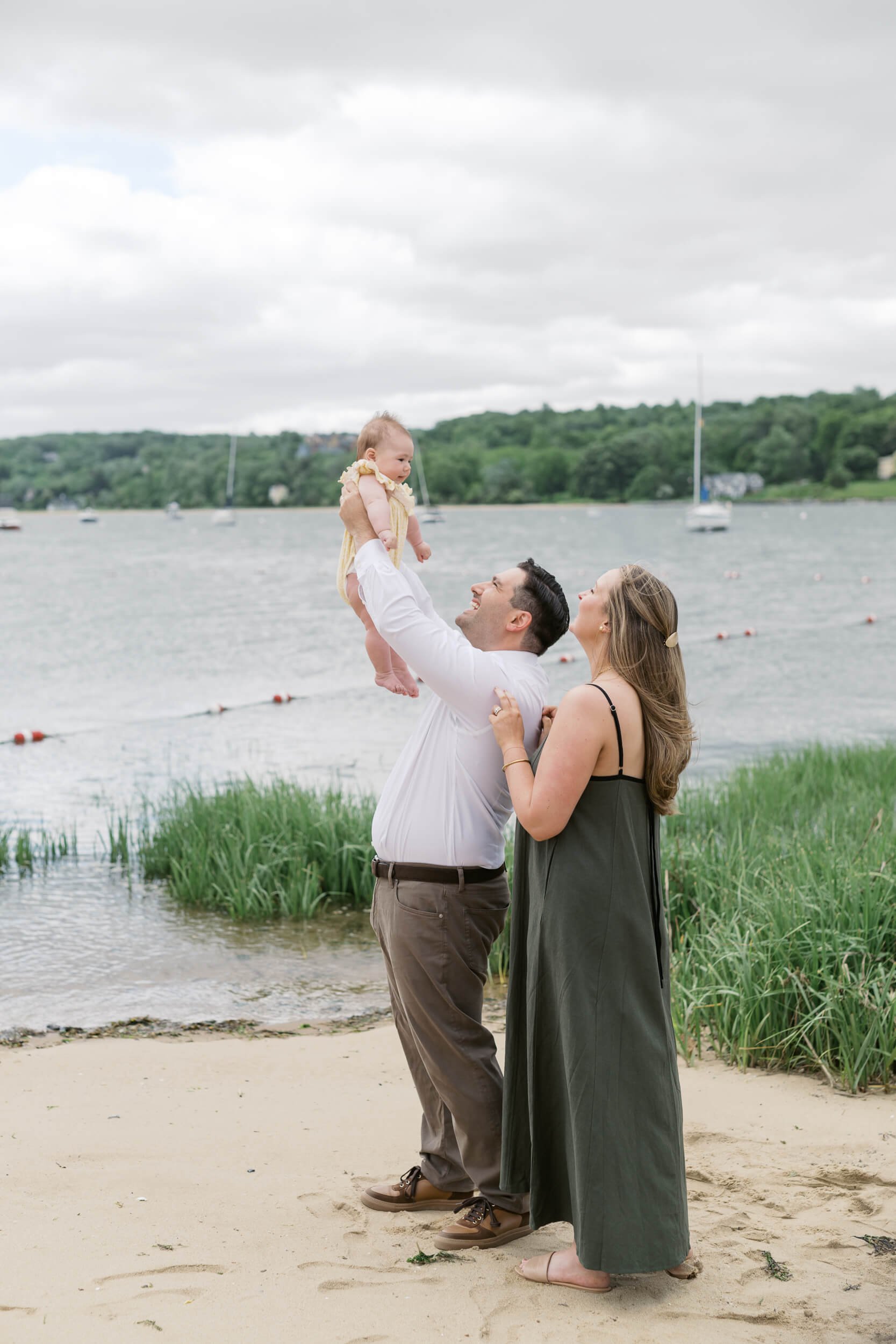 Dad holding Daughter up and smiling on beach