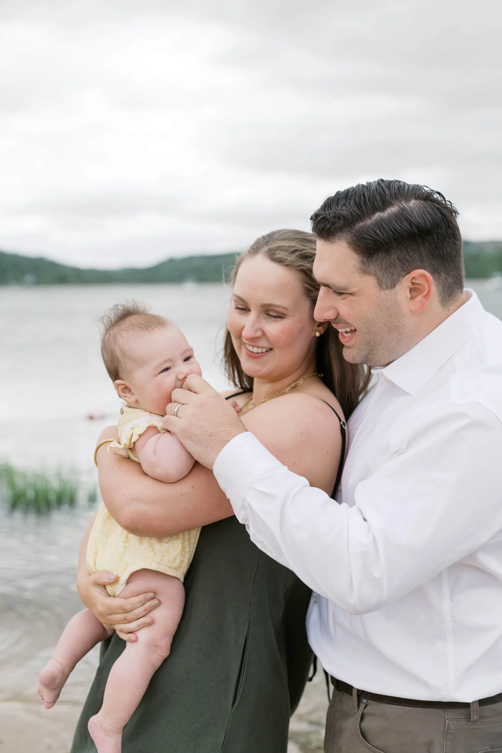 Baby Teething on Dad's fingers for sweet moment during family photos