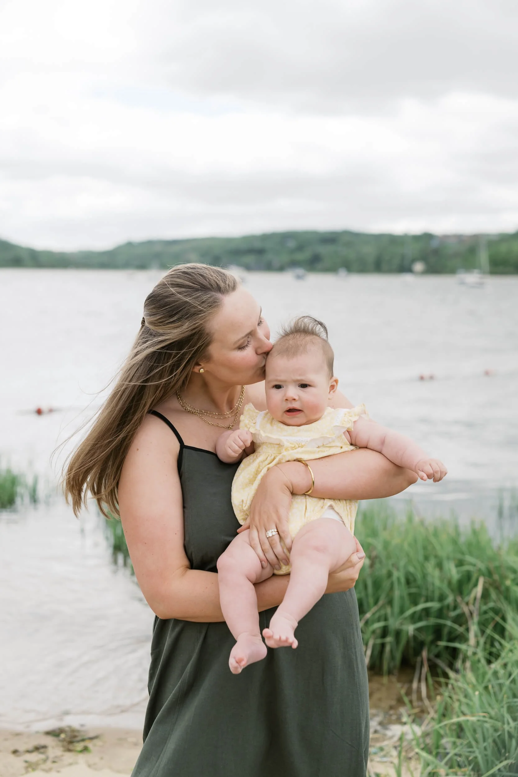 Mom gives baby a kiss on the forehead during family photos
