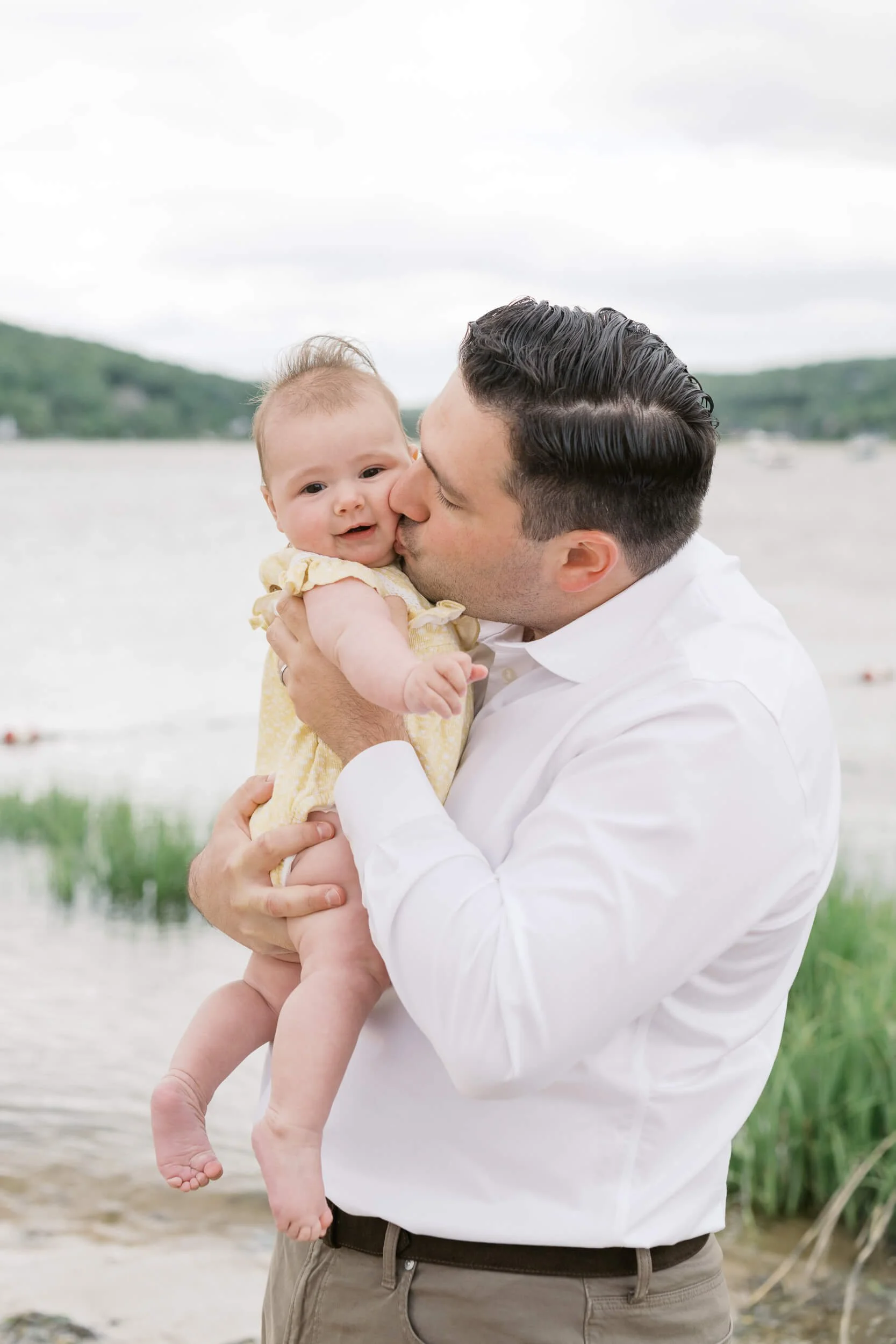 Dad Kissing Daughter during beach family photo session