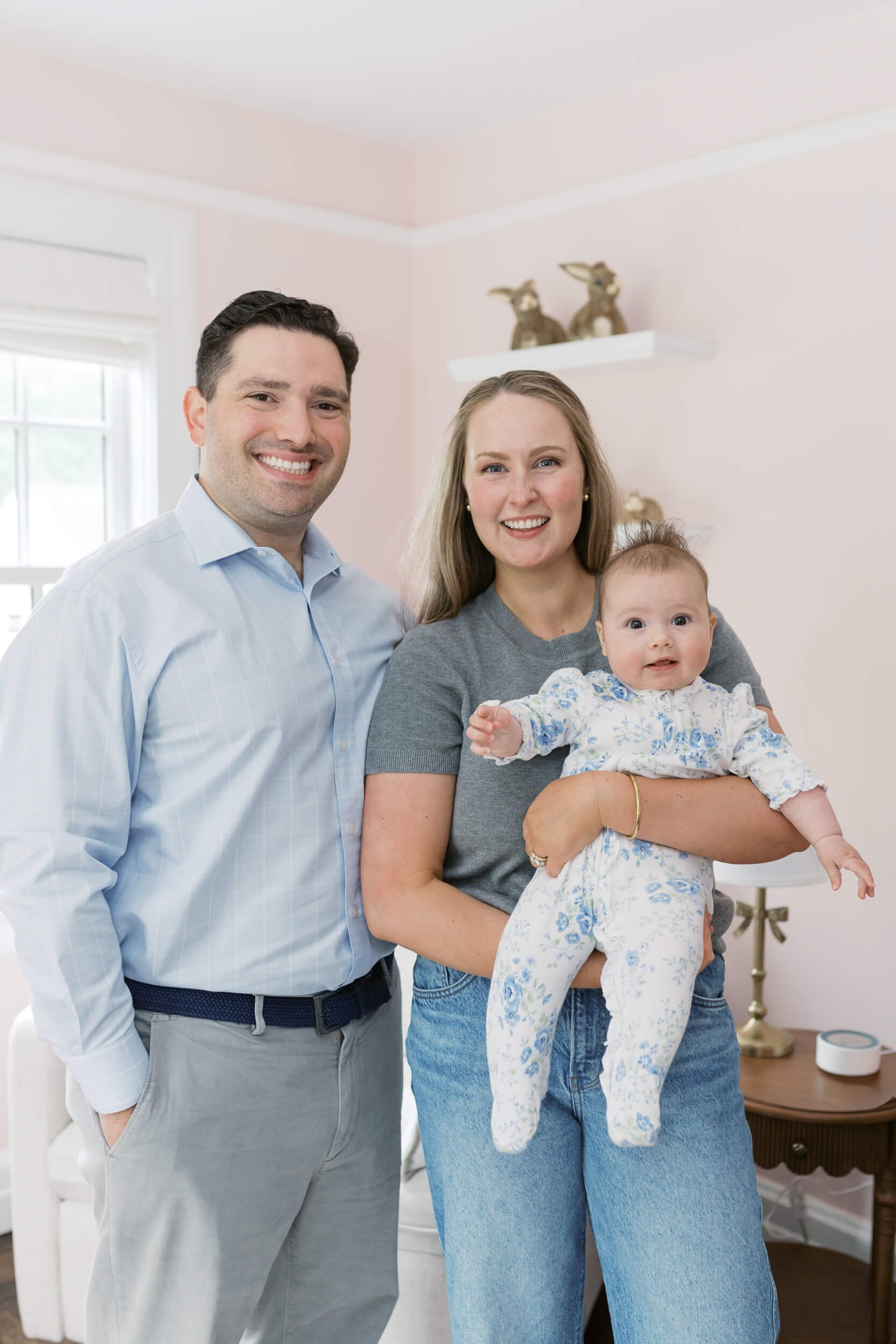 A six month old girl smiles at her parents inside her bunny themed nursery in Cold Spring Harbor.