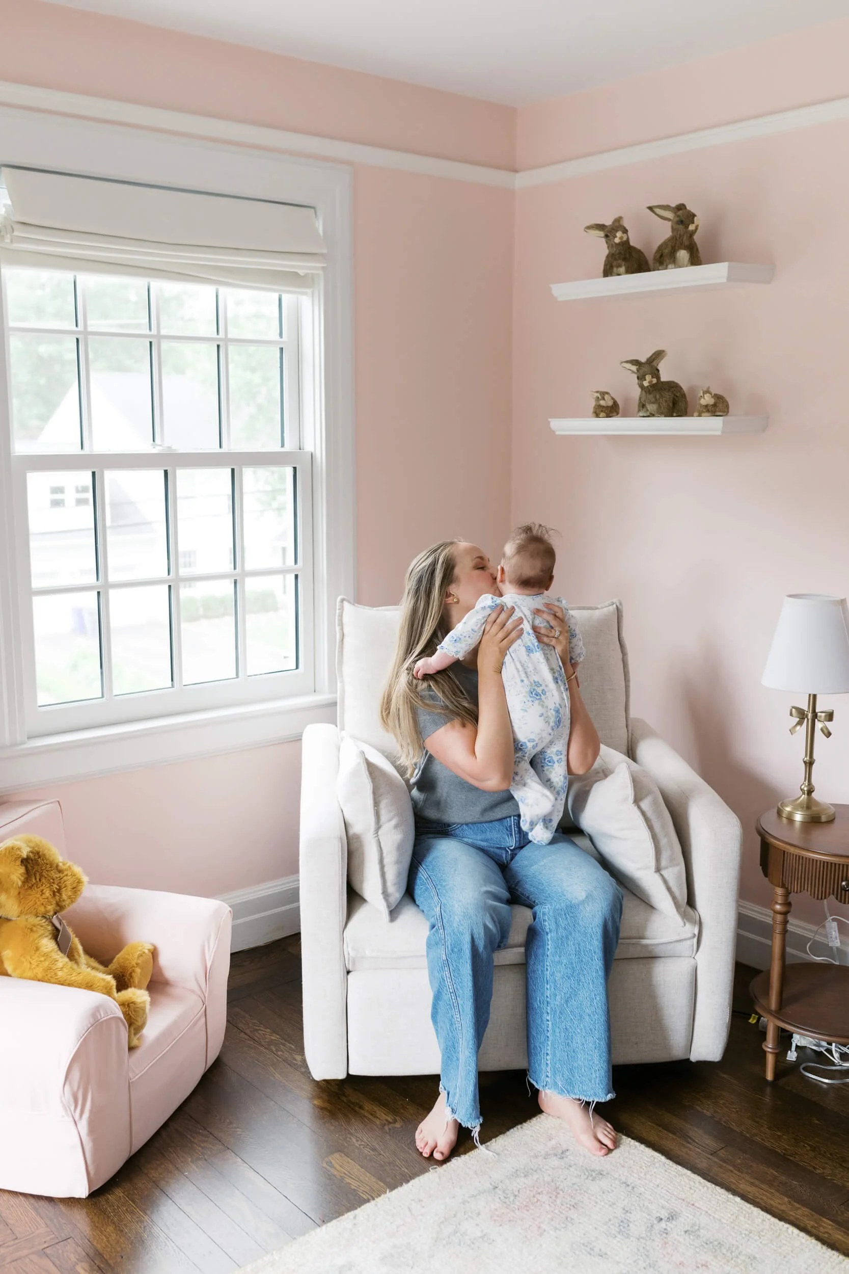 Parents and their daughter sit together in natural light for milestone family photos in Cold Spring Harbor, NY.