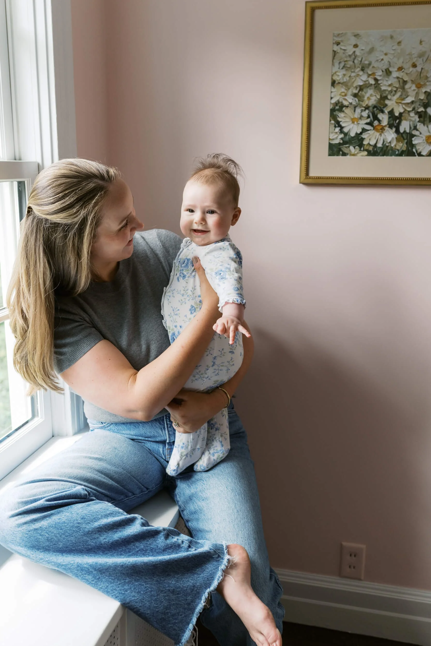 A tender family moment in the nursery, part of a six month milestone session with a Long Island family photographer.