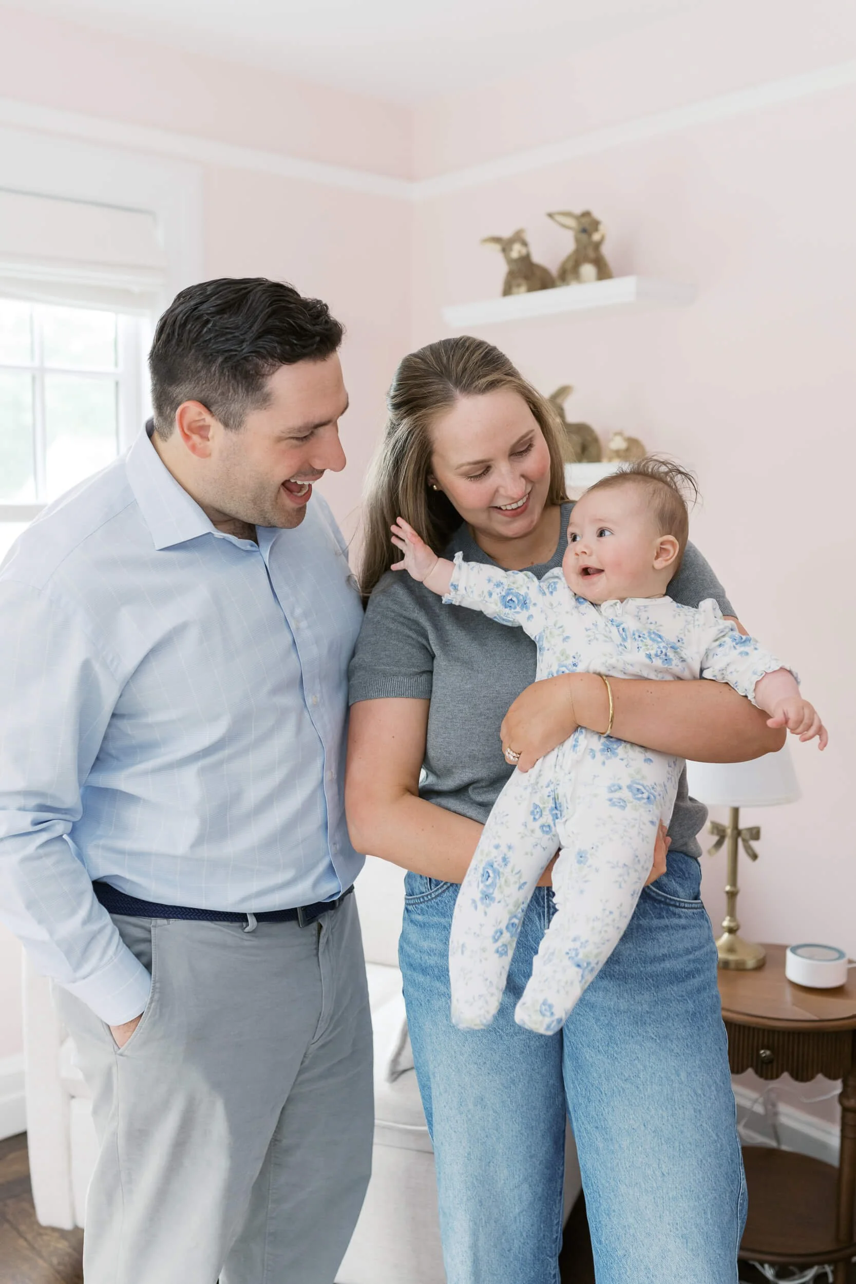 A six month old girl smiles at her parents inside her bunny themed nursery in Cold Spring Harbor.