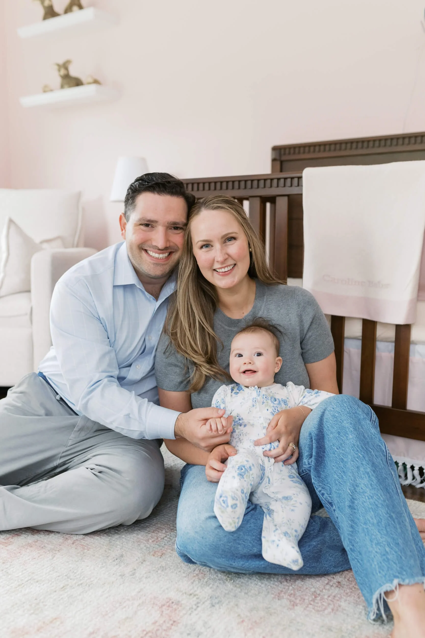 A six month old girl smiles at her parents inside her bunny themed nursery in Cold Spring Harbor.