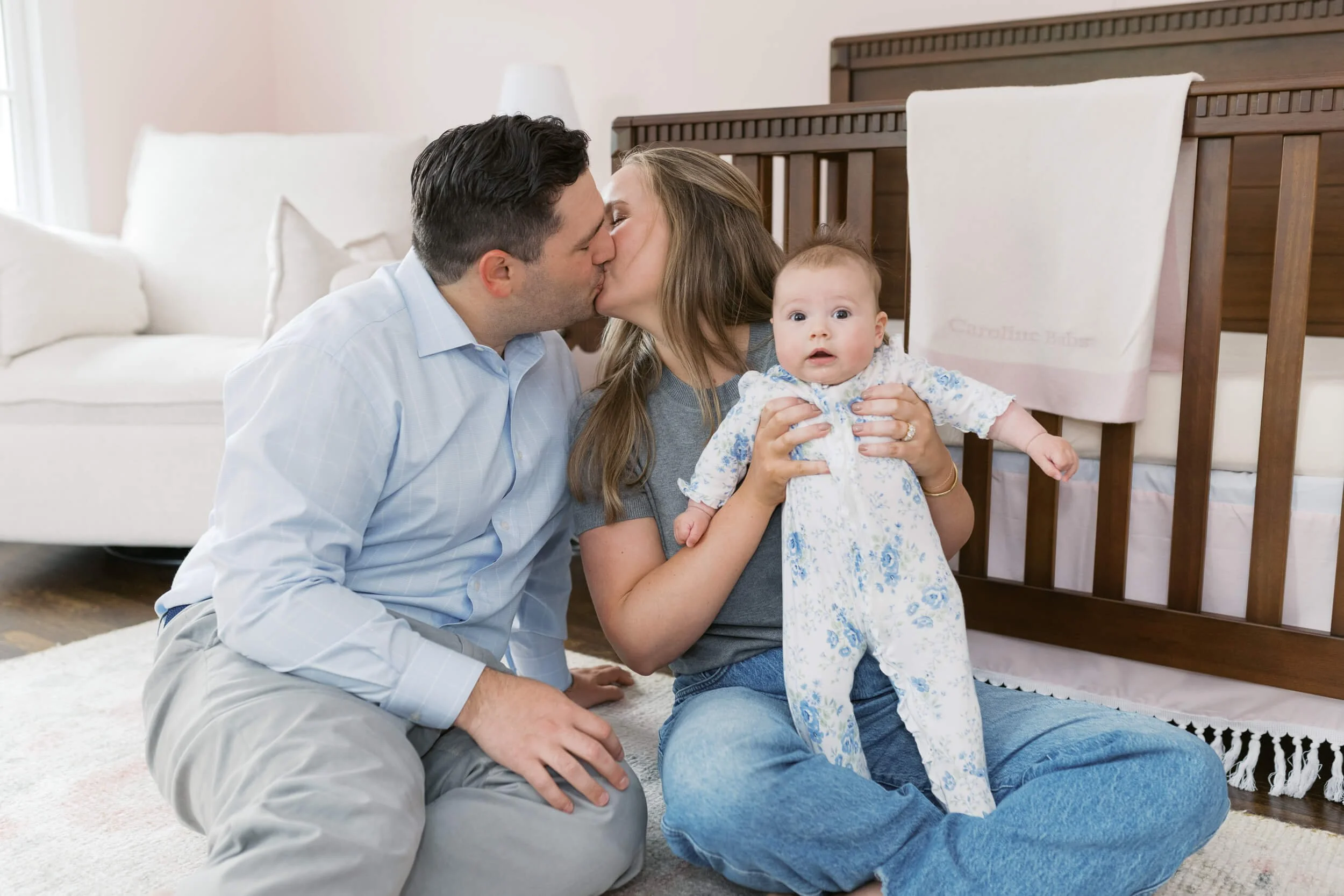 Parents and their daughter sit together in natural light for milestone family photos in Cold Spring Harbor, NY.