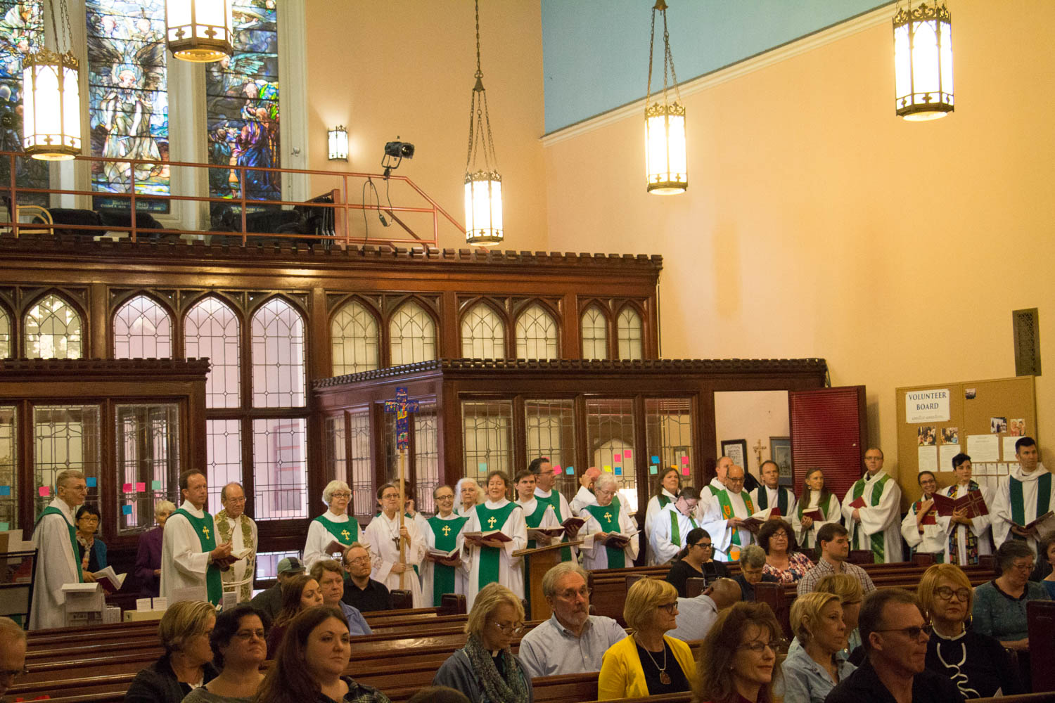 A gigantic procession of pastors and Chorale singers wait eagerly in the back as Pastor Gary says a word of welcome at the pulpit.
