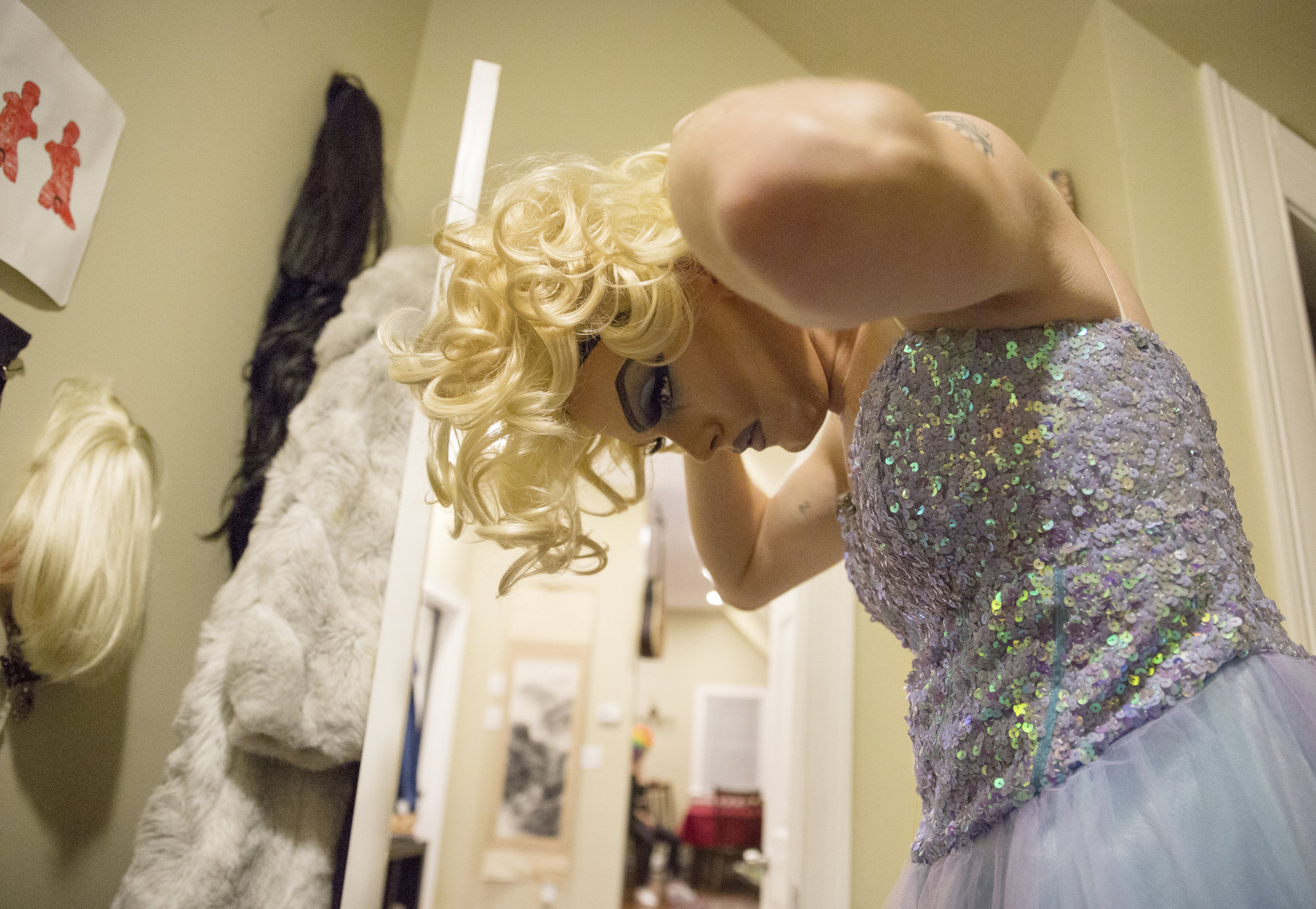 As his friends trickle into his Mission Hill loft, Mount tries on different wigs from his collection. He spends several minutes trying on each of his wigs and gathers input from him friends before settling on one.