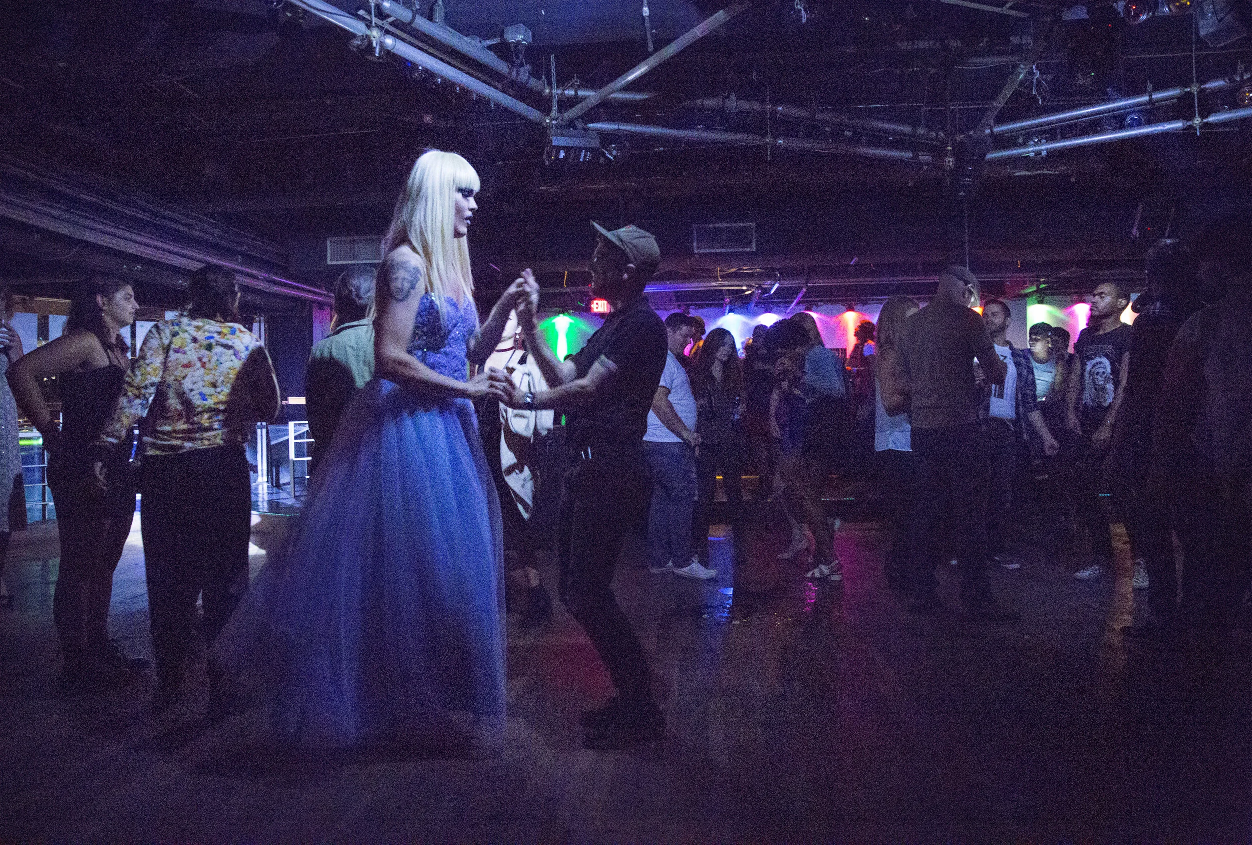 At nearly seven feet tall with heels, Ophelia towers over boyfriend James Richardson as they dance in Machine Nightclub before her performance.