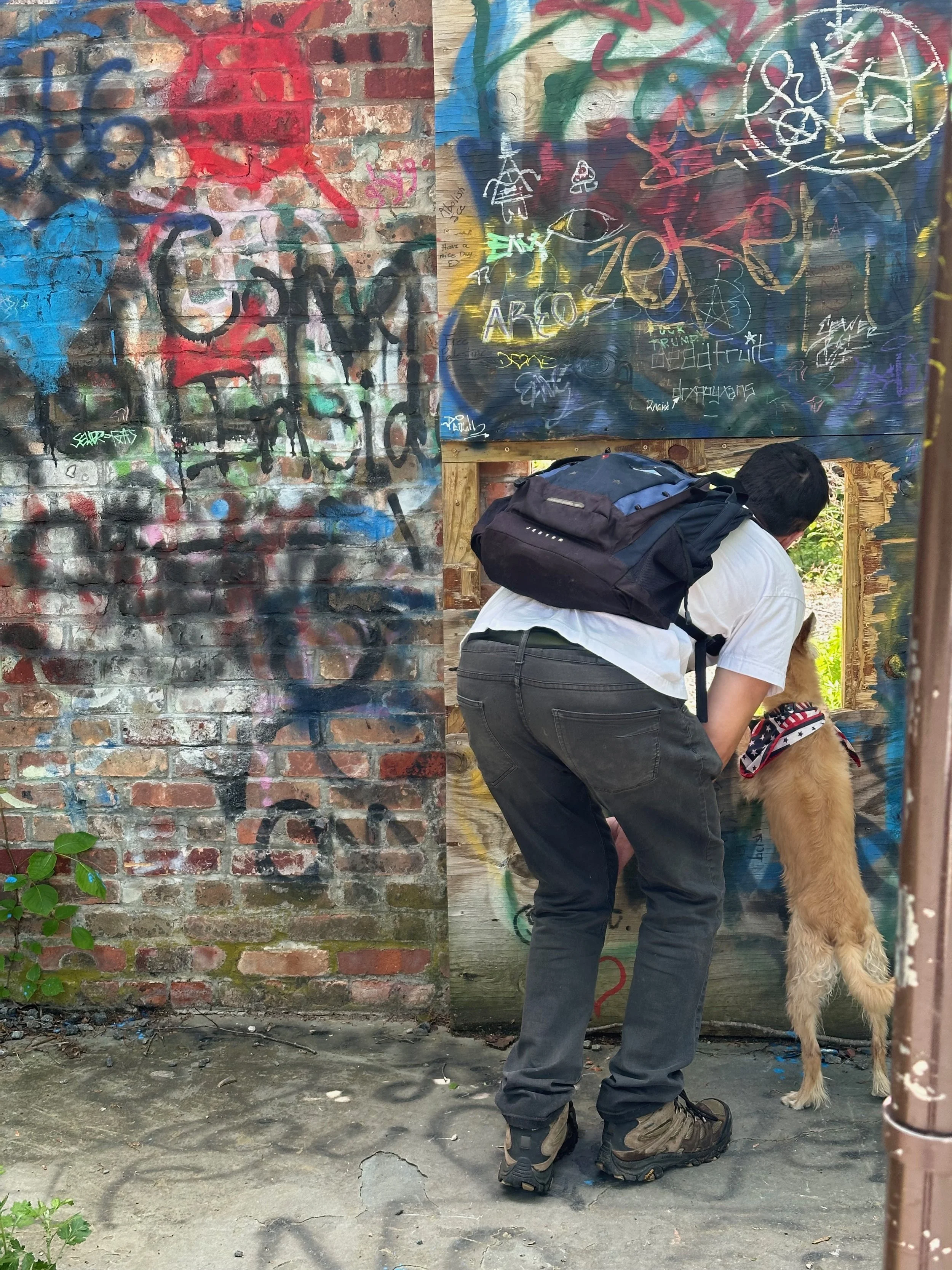 Joe Bertino facing a wall outdoors with his dog