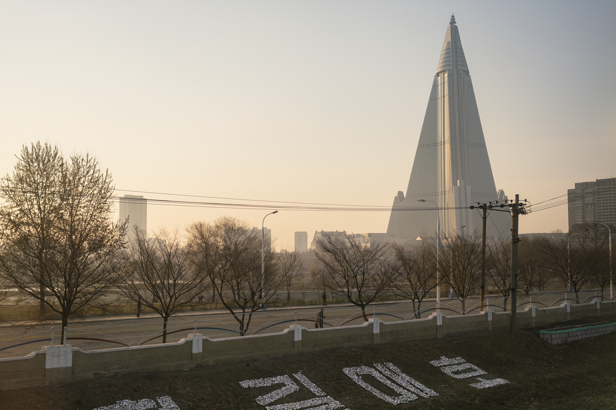  Arriving in Pyongyang, the Ryugyong Hotel dominates the scenery of the city since dawn.  Backed initially by the Soviet Union, the construction on the mysterious building–nicknamed “Hotel of Doom” due to the continuous interruptions on its completio