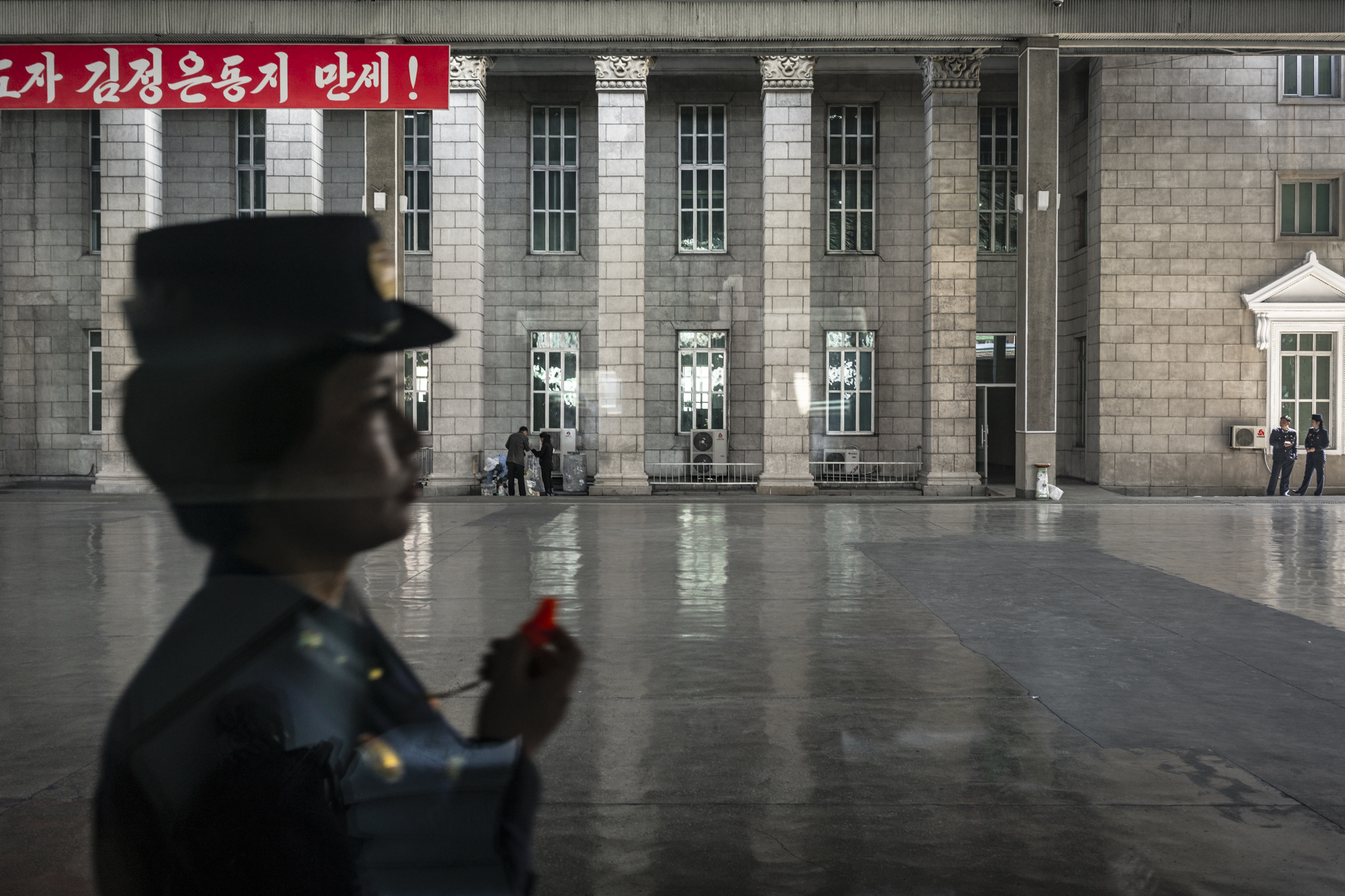  A train station officer with a whistle on the platform at Pyongyang Railway Station. 