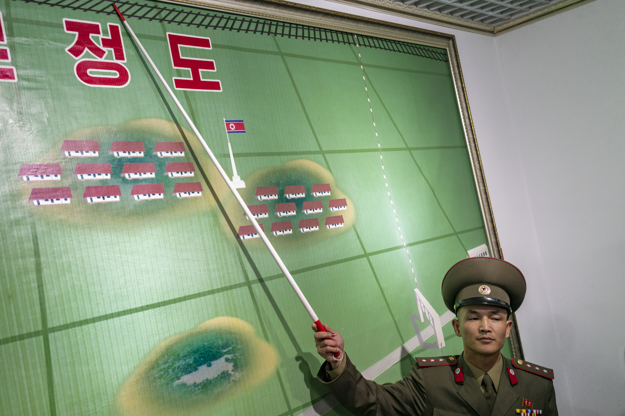  A North Korean soldier points a map of the border between North and South Korea in the DMZ.  