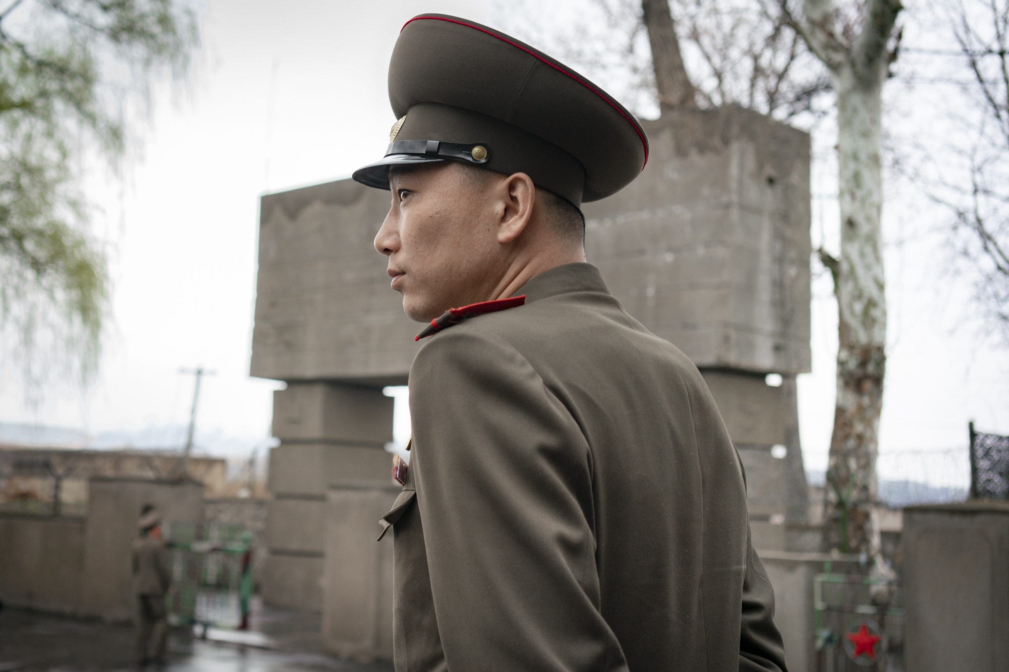  A uniformed North Korean army official is supervising the operations at the entrance of the DMZ in Kijŏng-dong.  The Korean Demilitarized Zone (DMZ) is a strip of land running across the Korean Peninsula serving as a buffer zone between North and So