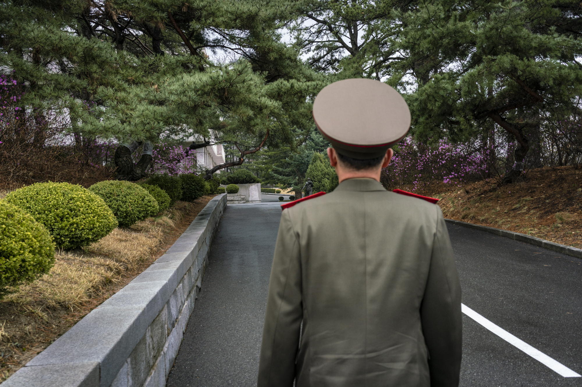  A uniformed North Korean army official is walking on the pathway towards the Joint Security Area (JSA) on the North Korea side.  Inside the DMZ, the Joint Security Area (JSA) is an area jointly policed by South and North, established as negotiating 