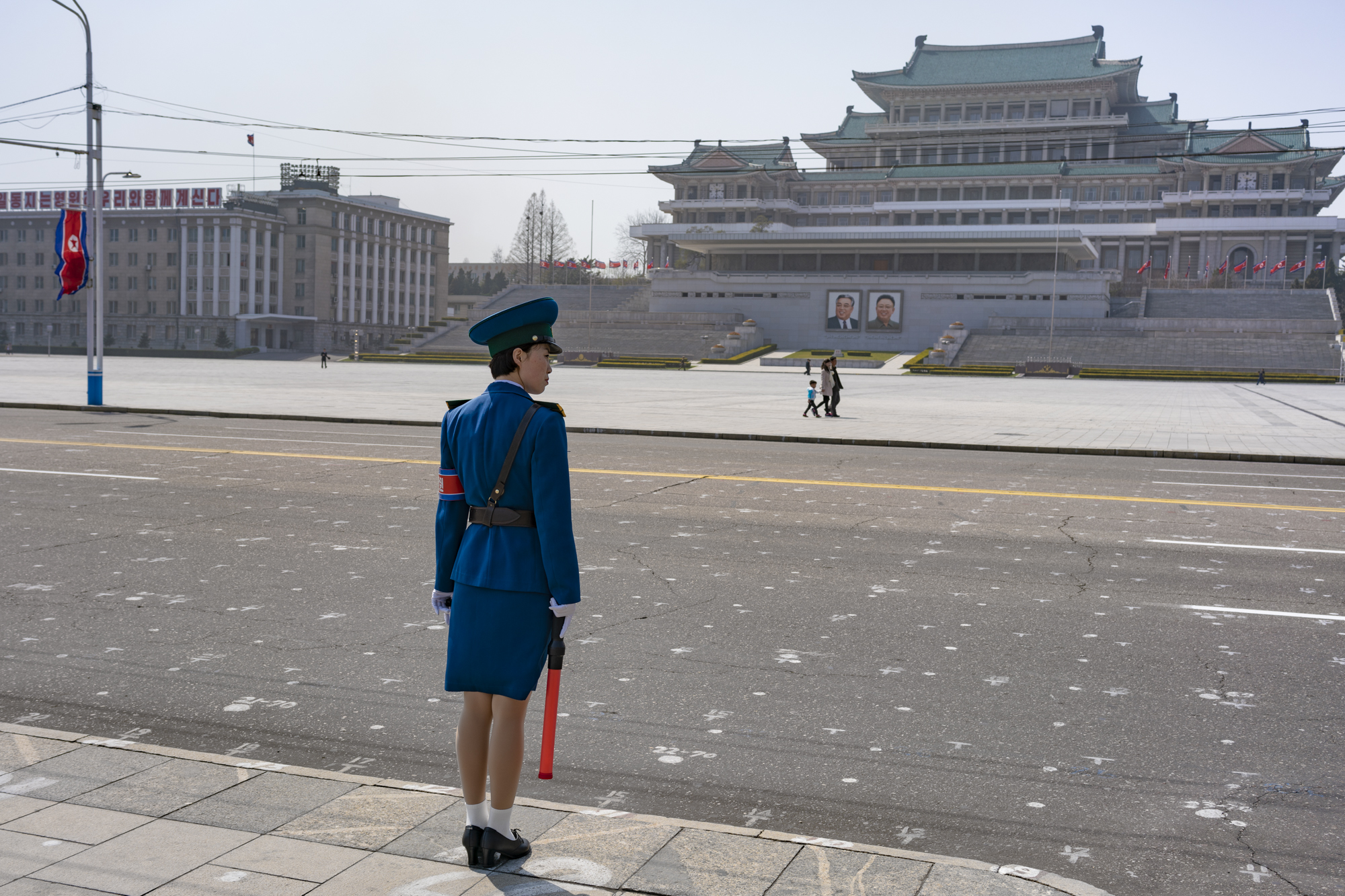 A North Korean traffic security officer stands on duty on a deserted intersection in Kim II Sung Square. Chosen for their look and highly desired by the DPRK’s male population because of their beauty and high social status, the traffic officers hav