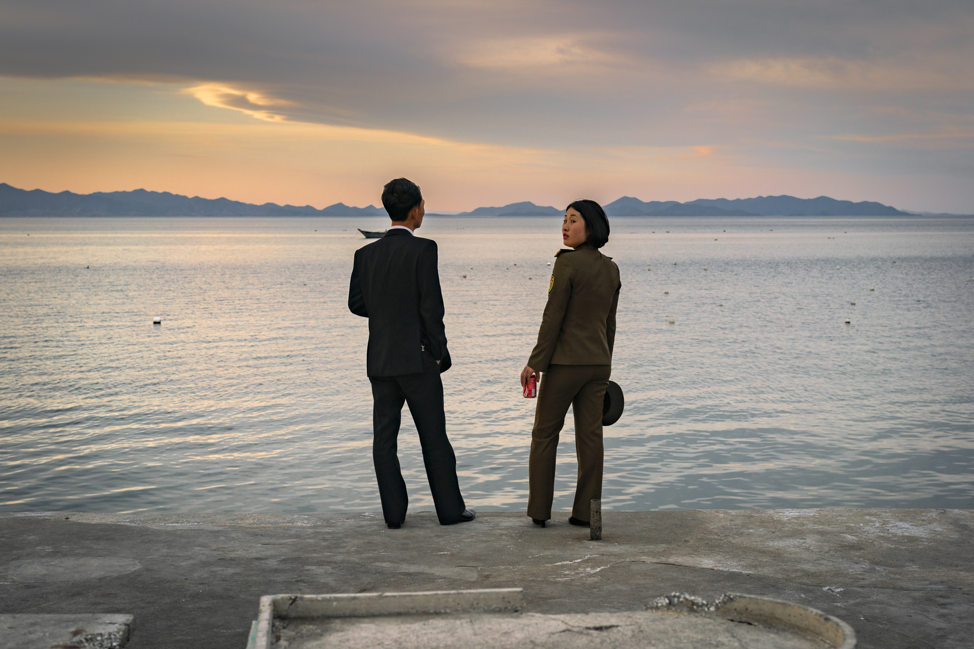 A couple watches the sunset over Yonghung Bay on the pier to Jangdok Islet.