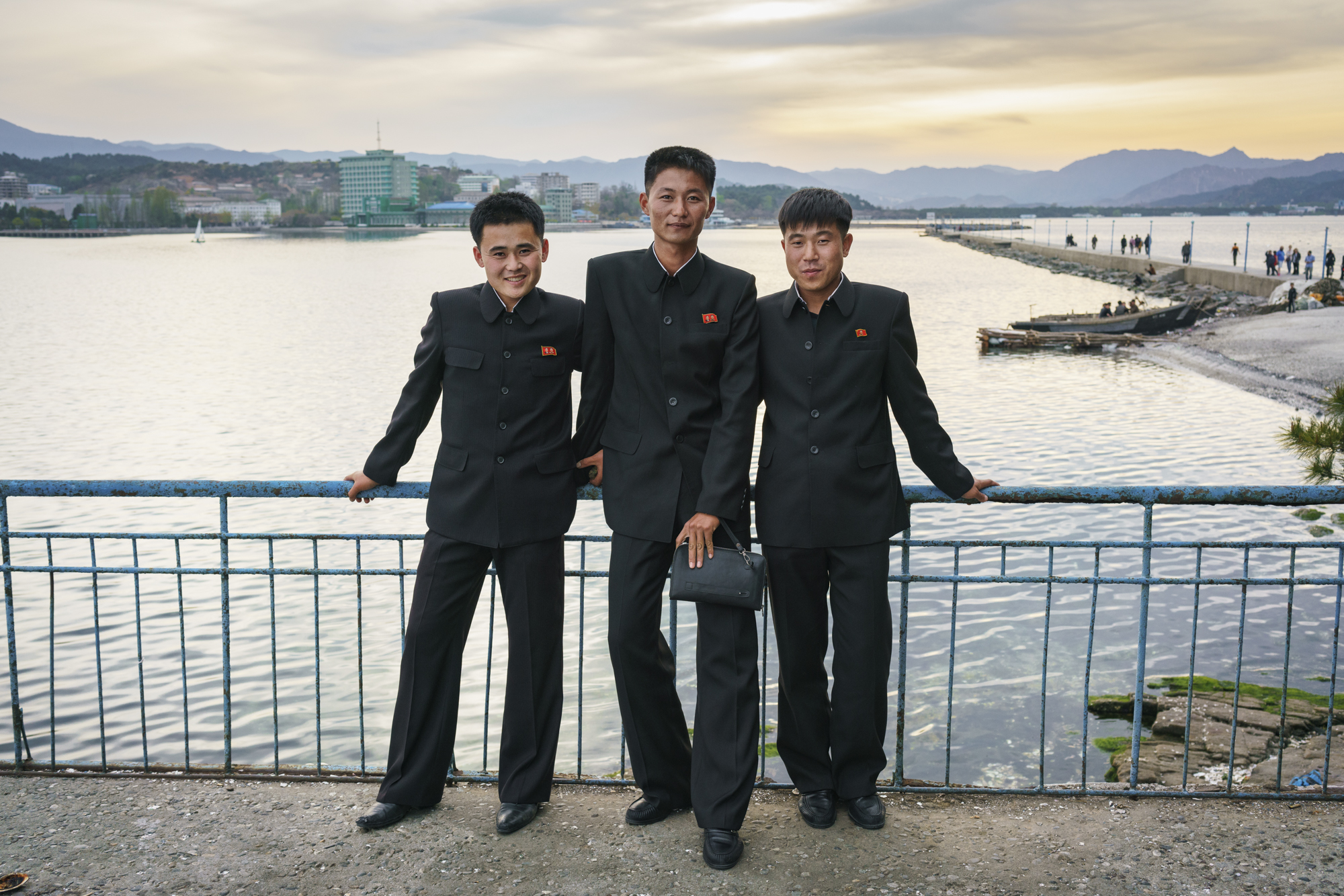  On Jangdok Islet, three North Korean students enjoy the sunset on the panoramic balcony that faces the city of Wŏnsan.  The small island is known for the Changdokdo lighthouse, built by the Japanese in 1919 to help in their trading enterprises. 